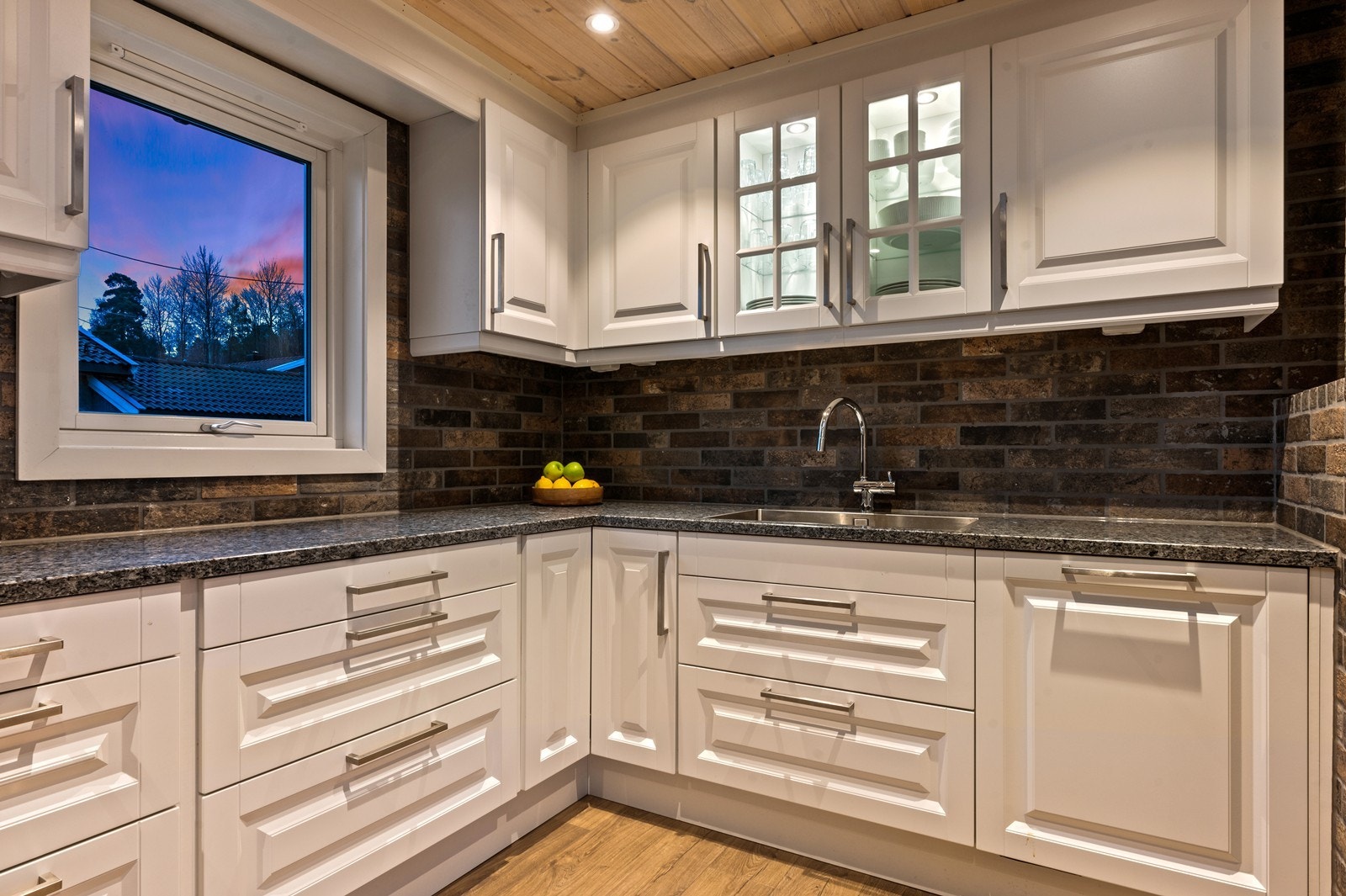 Granittbenkeplate og integrert oppvaskmaskin gir en funksjonell arbeidsplass på kjøkkenet. Galleribilde