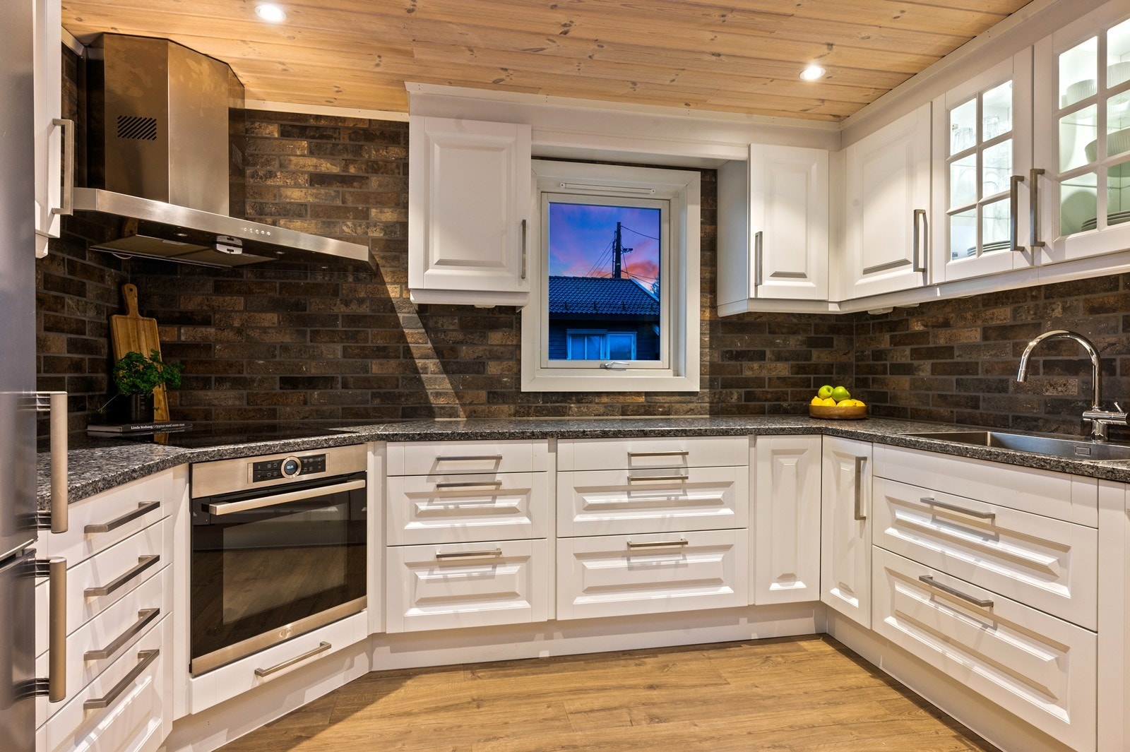 Kjøkkenet har profilerte, lyse fronter og benkeplater i granitt fra 2016, med integrerte hvitevarer. Galleribilde