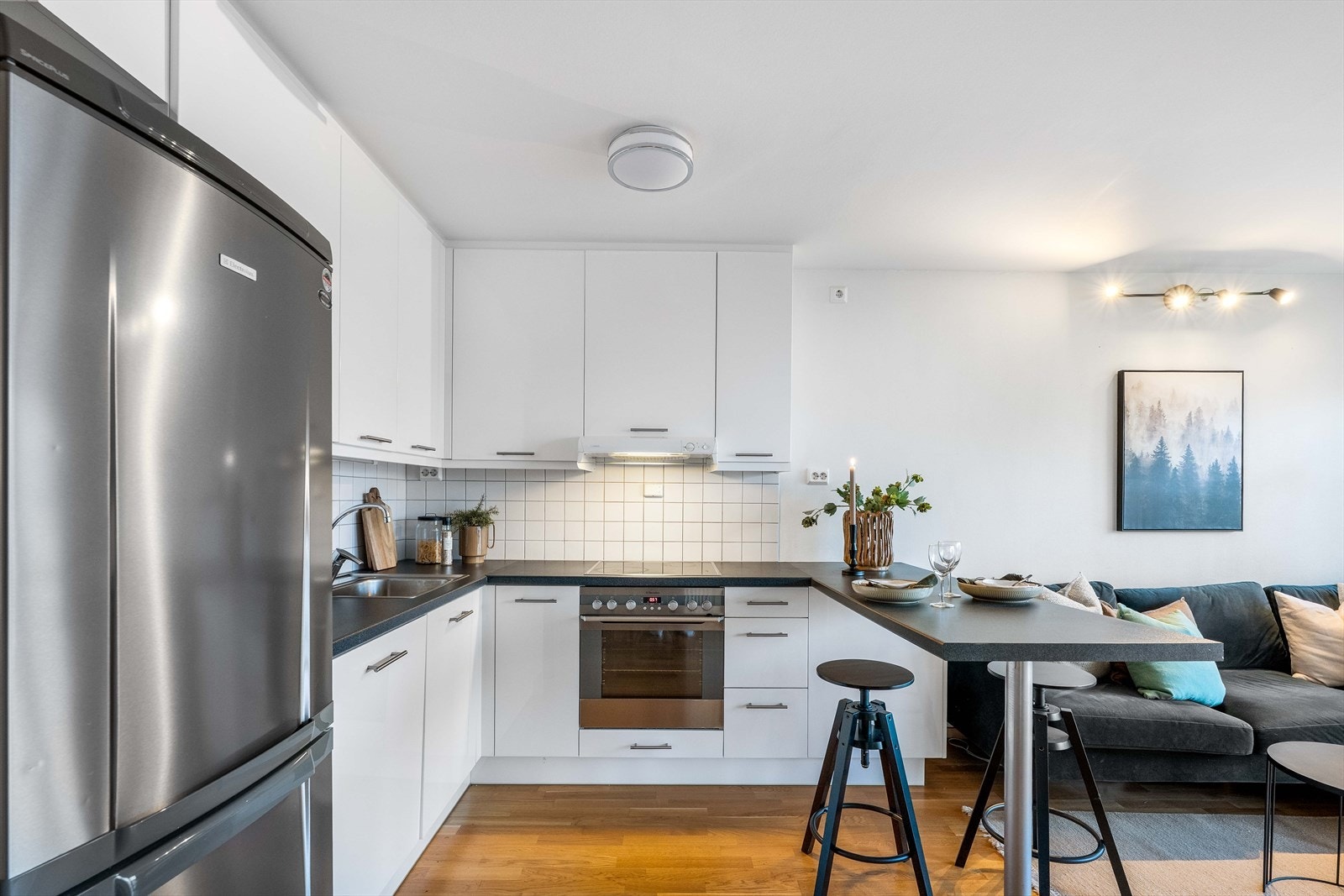 Den takoppforede kjøkkeninnredningen har glatte fronter og en laminert benkeplate med fliser på veggen over. Galleribilde