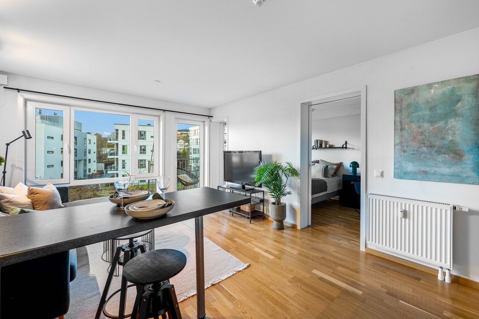 Leiligheten fremstår innbydende med hvitmalte vegger og parkettgulv. Legg merke til listfri overgang mellom vegger og himling. Galleribilde