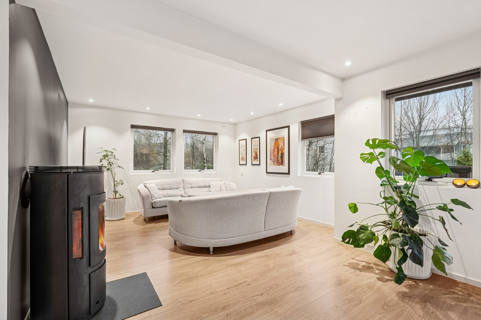 Stuen har utstrakt bruk av downlights og mange vindusflater, noe som skaper en luftig atmosfære - Ildstedet gir hygge og ikke minst rask oppvarming Galleribilde