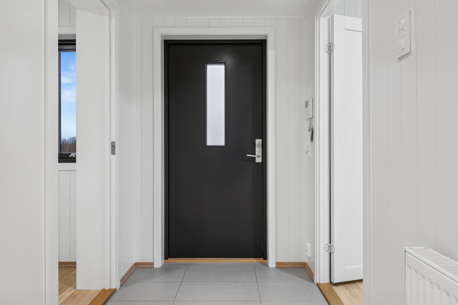 Praktisk flislagt sone ved inngangsdøren gir en robust og lettstelt løsning. Galleribilde