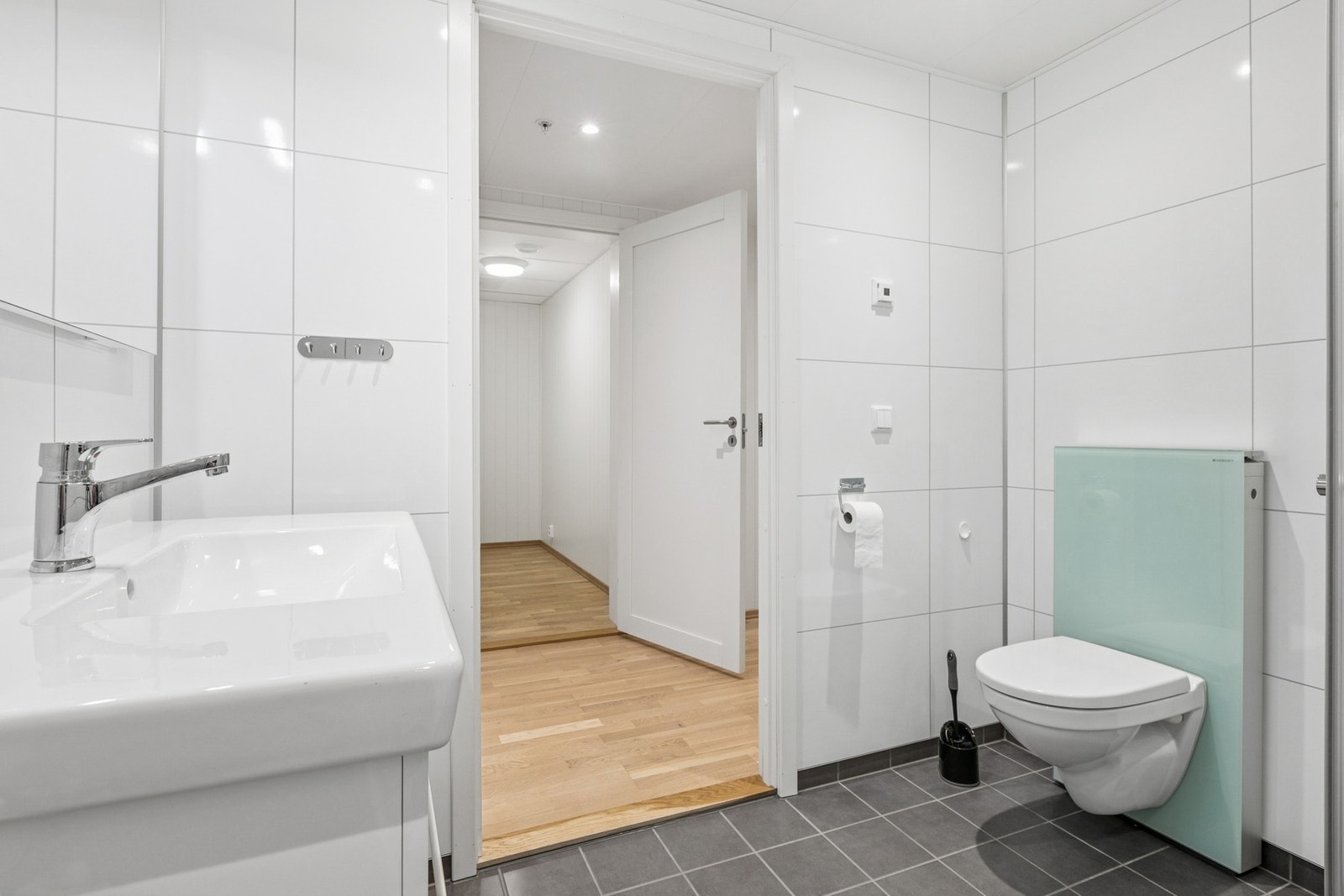 Flislagt gulv med behagelig gulvvarme, vegghengt servantskap med overliggende servant. Galleribilde