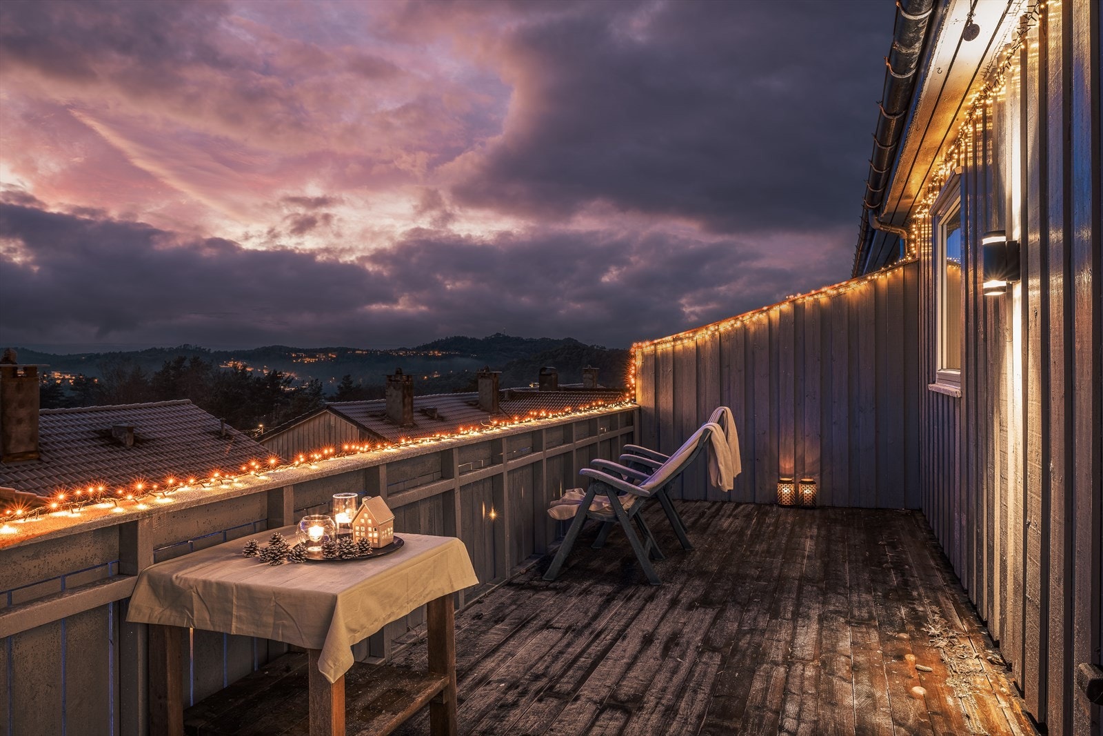 Koselig balkong med stemningsfulle lys og vakker utsikt over landskapet. Perfekt for avslapning og hygge hele året. Galleribilde