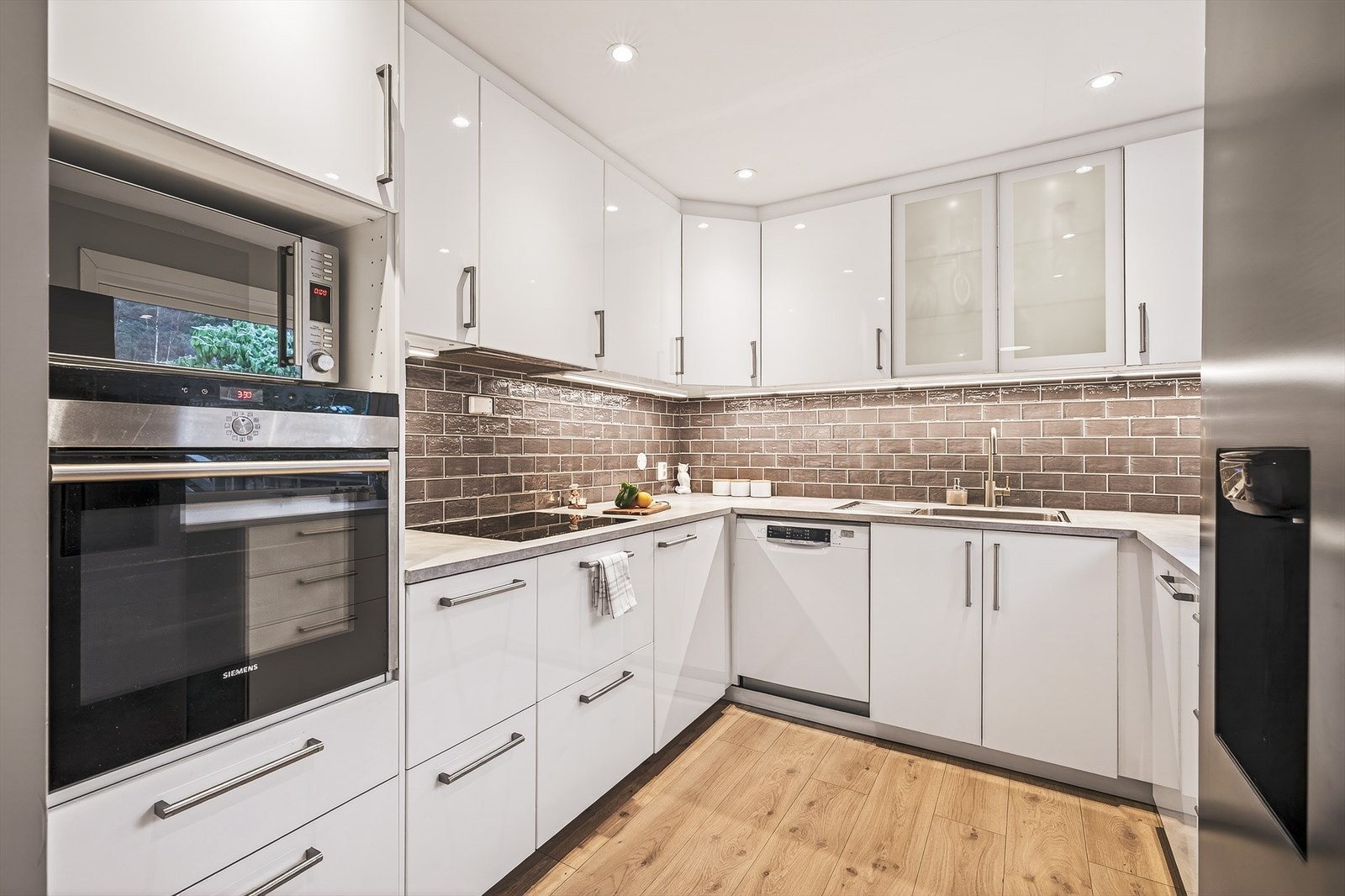 Moderne kjøkken med stilrene flater, integrerte hvitevarer, og smakfulle detaljer. Innfelte spotlights i himling. Galleribilde