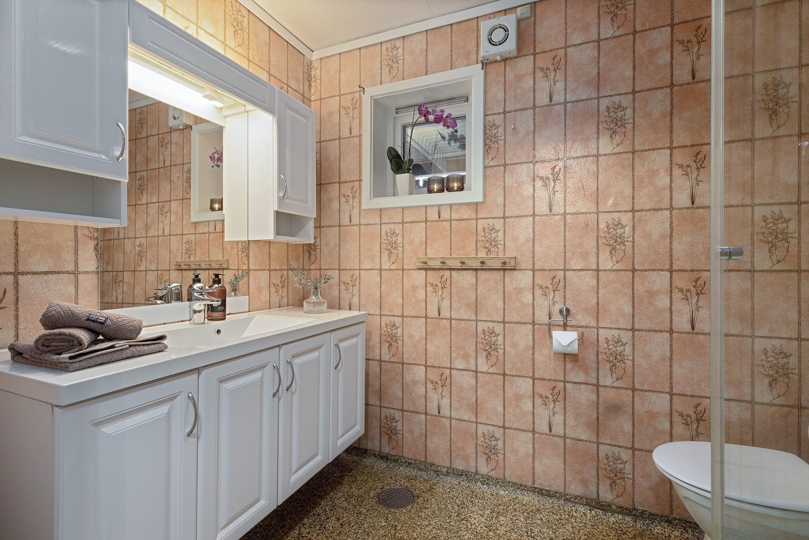 Badet i underetasjen er utstyrt med toalett, dusjhjørne og servant med innredning. Galleribilde