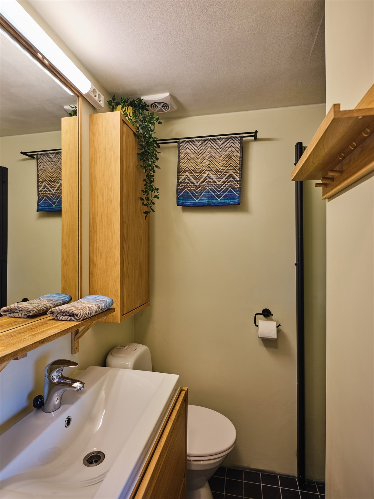 Bad i delikate farger med wc, servant m underskap og dusjnisje. Galleribilde