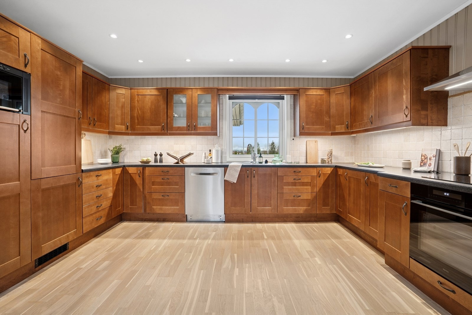 Kjøkkeninnredning med profilerte fronter og benkeplate av laminat med integrert platetopp, komfyr, mikro, kjøl/frys. Frittstående oppvaskmaskin og oppvaskkum av stål. Meget god skap- og benkeplass. Galleribilde