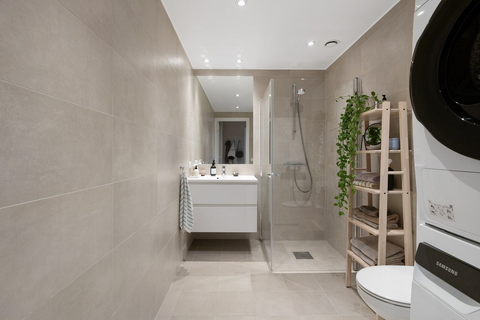 Badet har flislagte gulv, fliselagt vegger og malt slett himling med downlights. Galleribilde