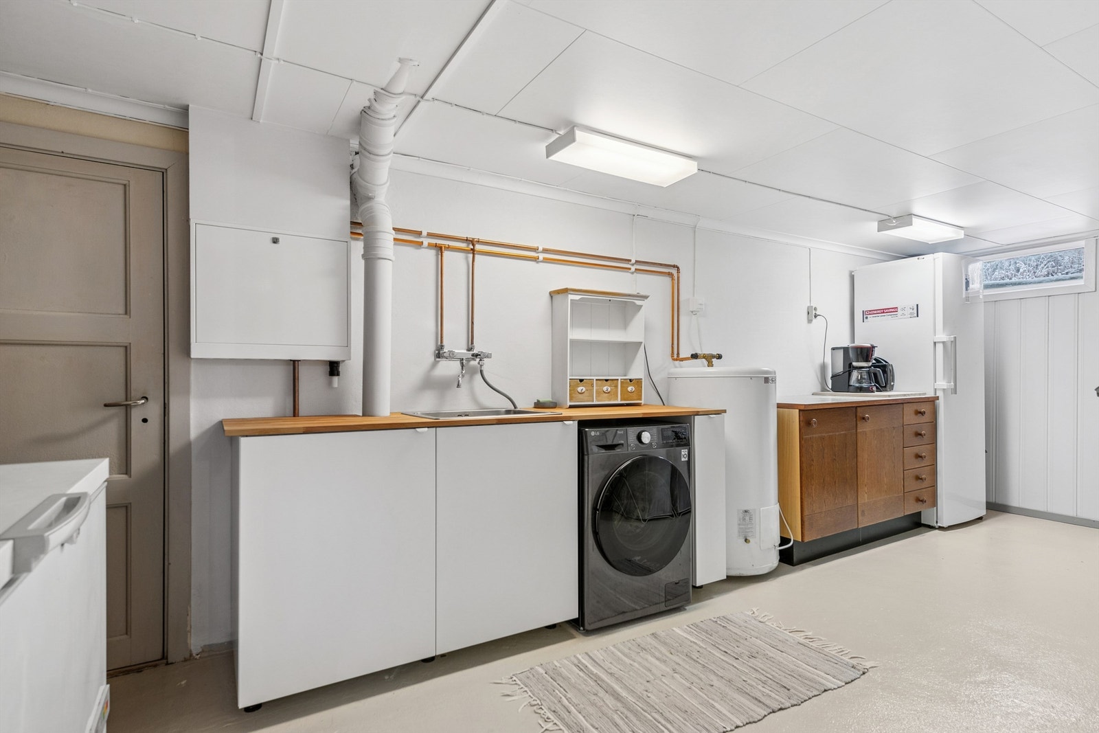 Separat vaskekjeller med praktisk innredning, benkeplate og opplegg for vaskemaskin. Galleribilde
