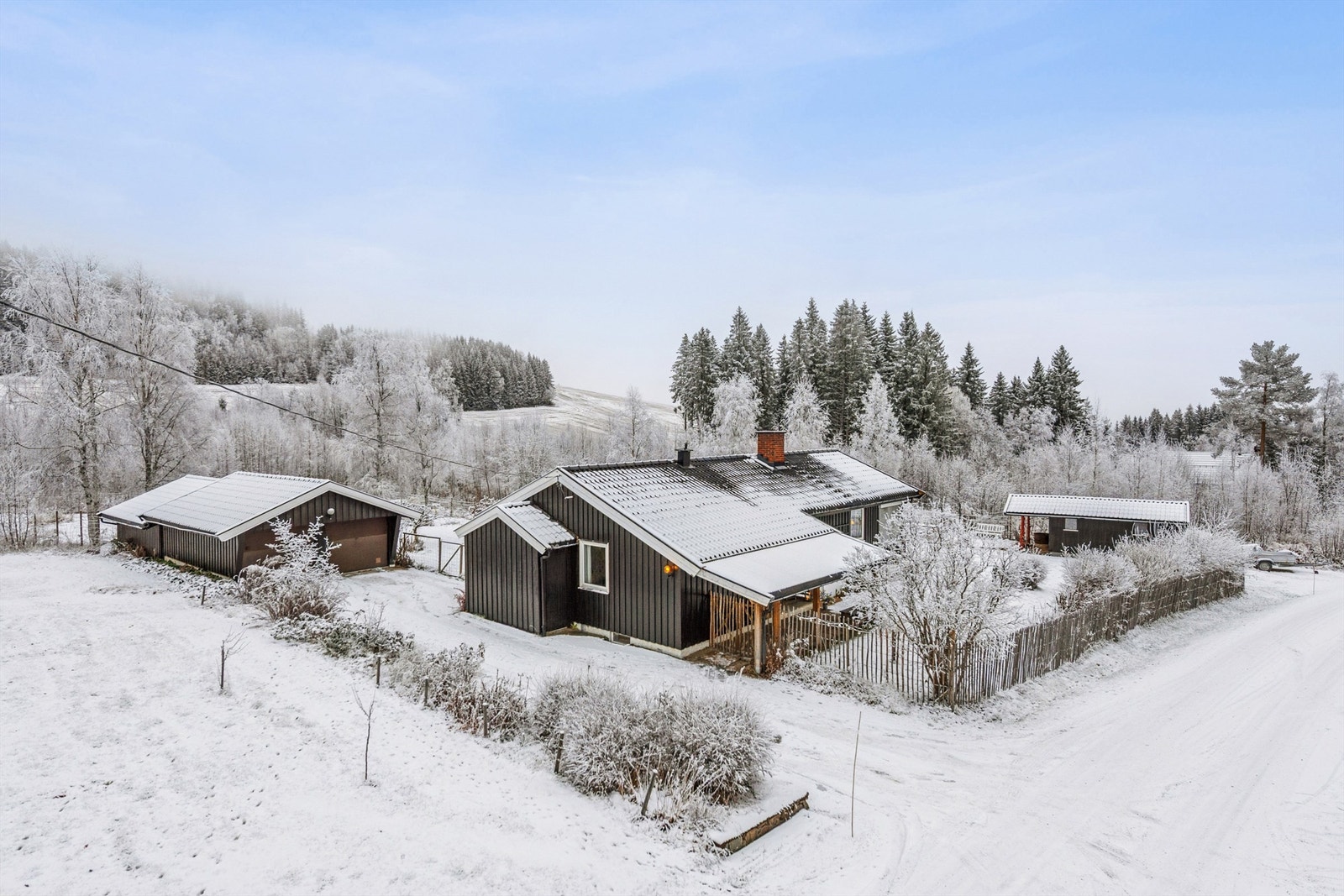 Eiendommen ligger på en stor tomt og inkluderer en dobbel garasje og et praktisk uthus. Galleribilde