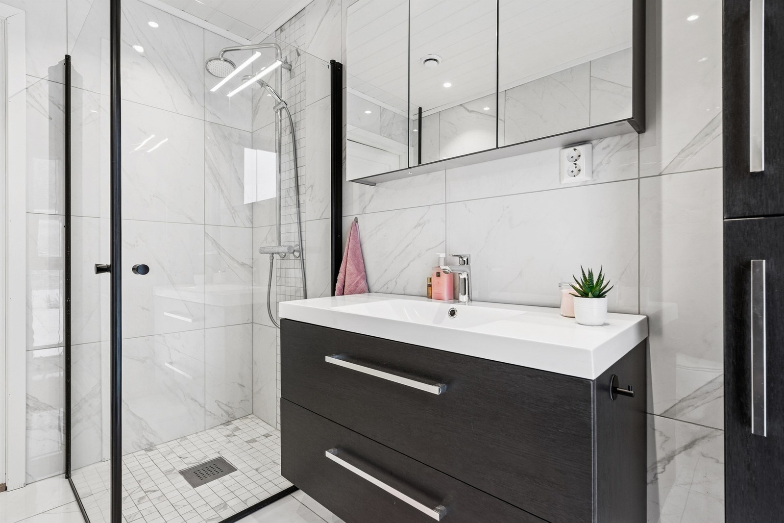 Innredningen består av servant med underskap, speilskap og et romslig dusjhjørne. Det er varmekabler i gulvet. Galleribilde