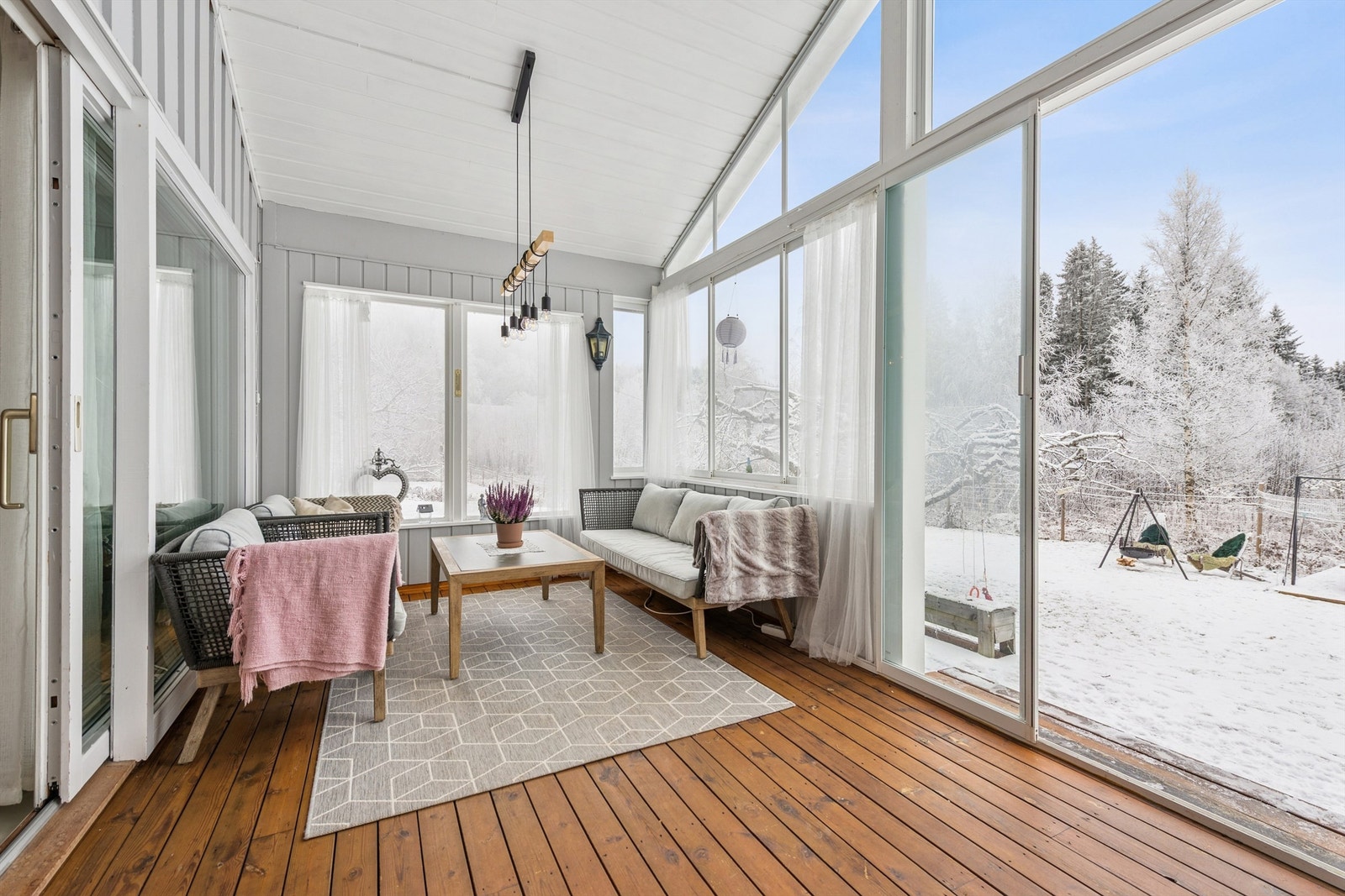 Store skyvedører i glass åpner opp mot hagen og slipper naturen inn. Galleribilde