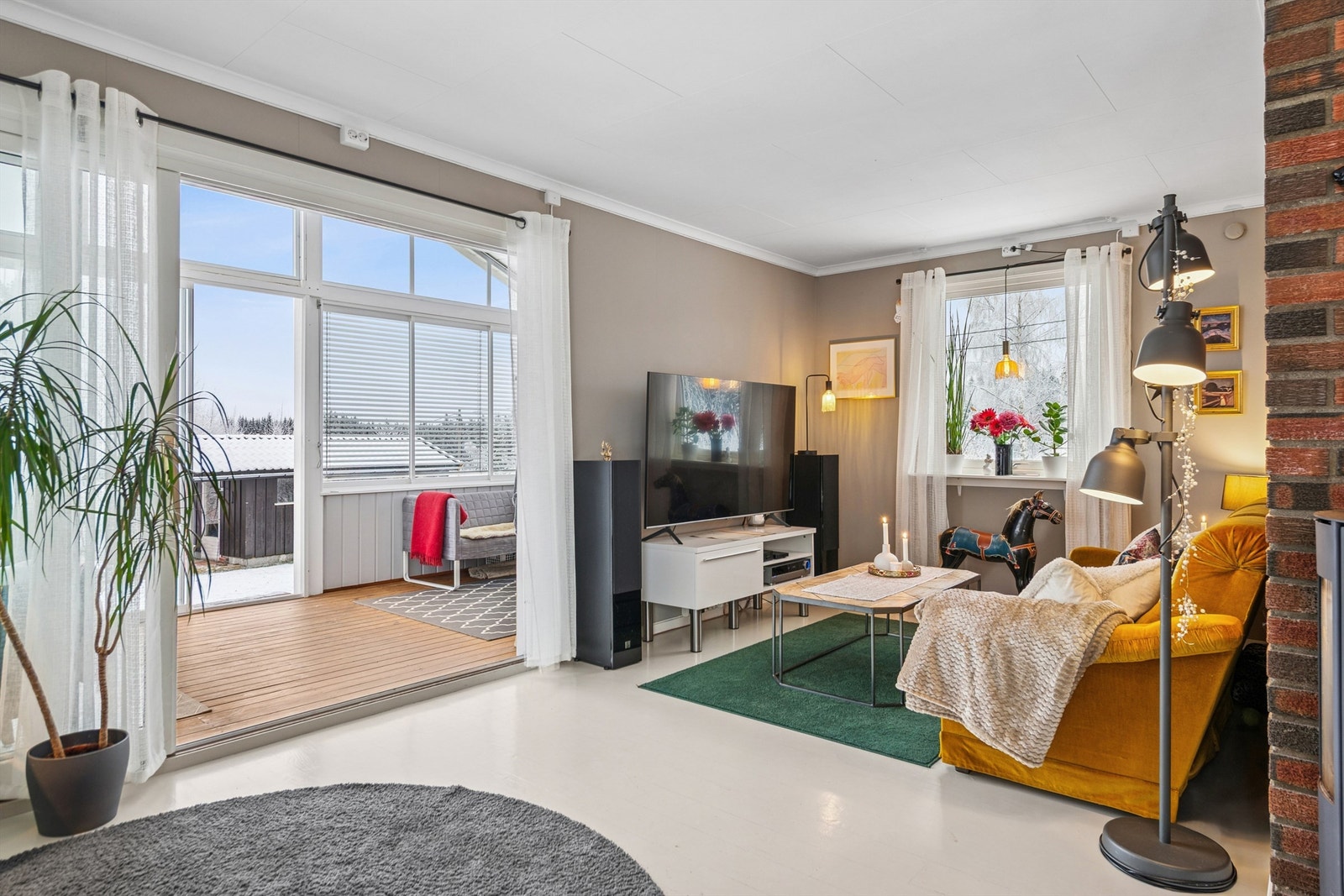 De store glassflatene gir rikelig med naturlig lys til stuen. Galleribilde