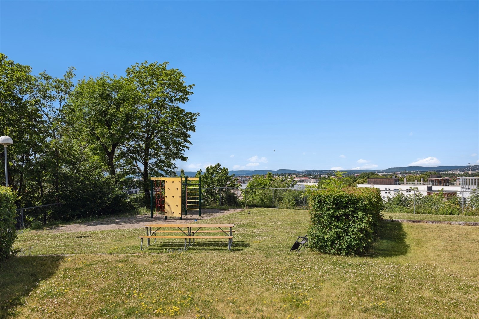 Bakgård med flotte gressplener, sittegrupper og lekestativ. Galleribilde