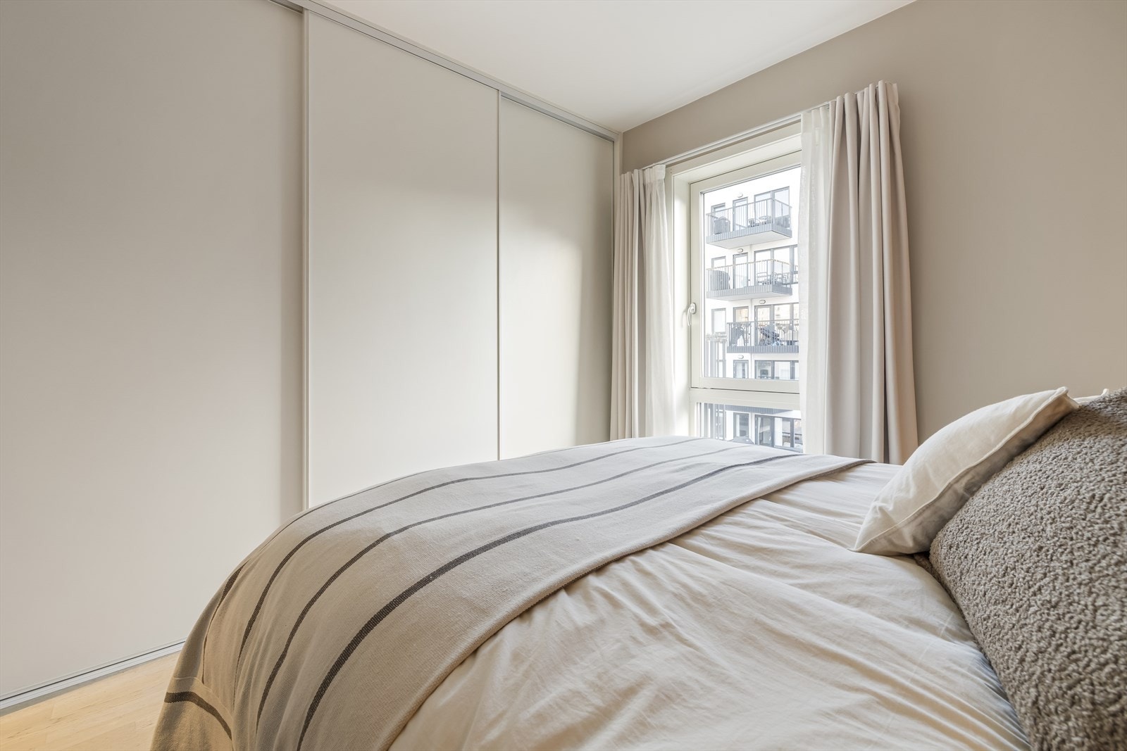 Rommet er romslig med god plass til dobbeltseng, nattbord samt en stor skyvedørsgarderobe med rikelig av oppbevaringsplass. Galleribilde