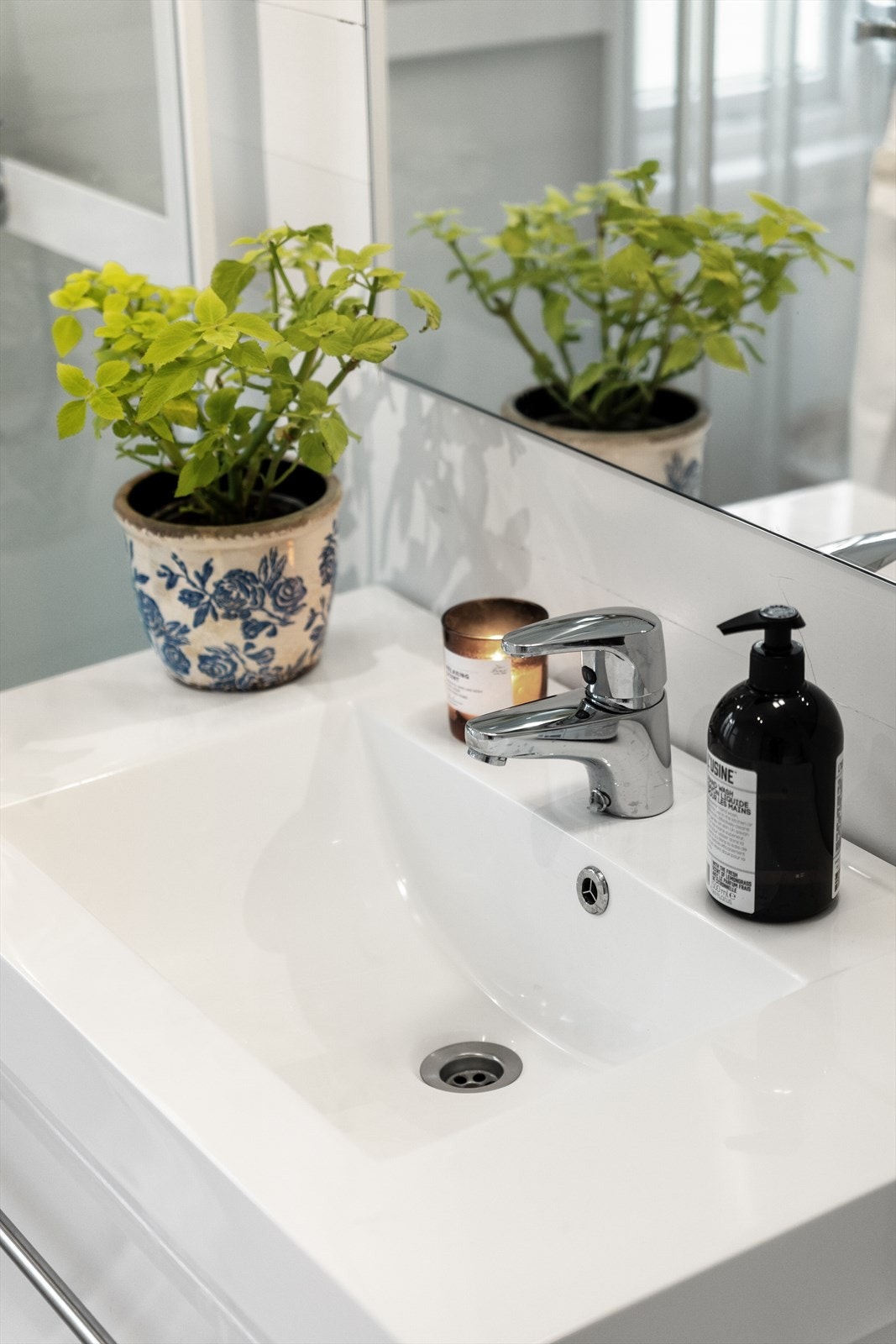 Badet har hvit baderomsinnredning med enkel servant Galleribilde