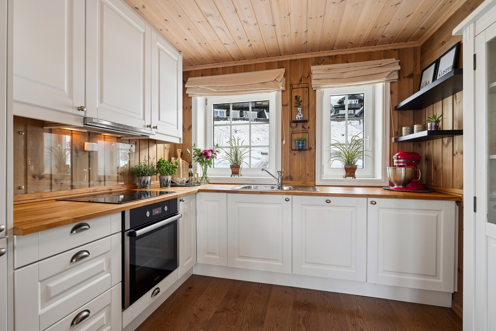 Lyst og innbydende kjøkken med klassiske detaljer og god arbeidsplass! Her får du en praktisk løsning med integrerte hvitevarer, rikelig benkeplass og store vinduer. Perfekt for både matlaging og hyggelige stunder på fjellet. Galleribilde