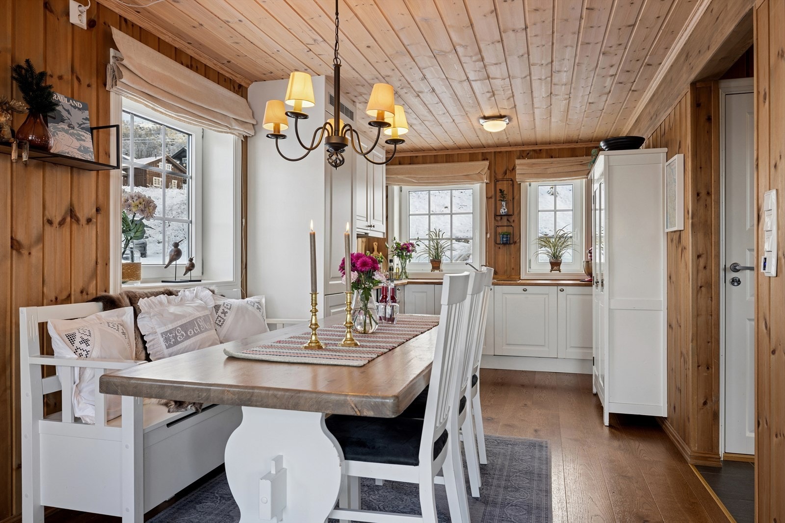 Lys og trivelig spiseplass med klassisk hyttepreg, sett fra stuen. Herfra har du utgang til gang og entré, og en åpen løsning mot kjøkkenet som gir en sosial og praktisk atmosfære. Galleribilde