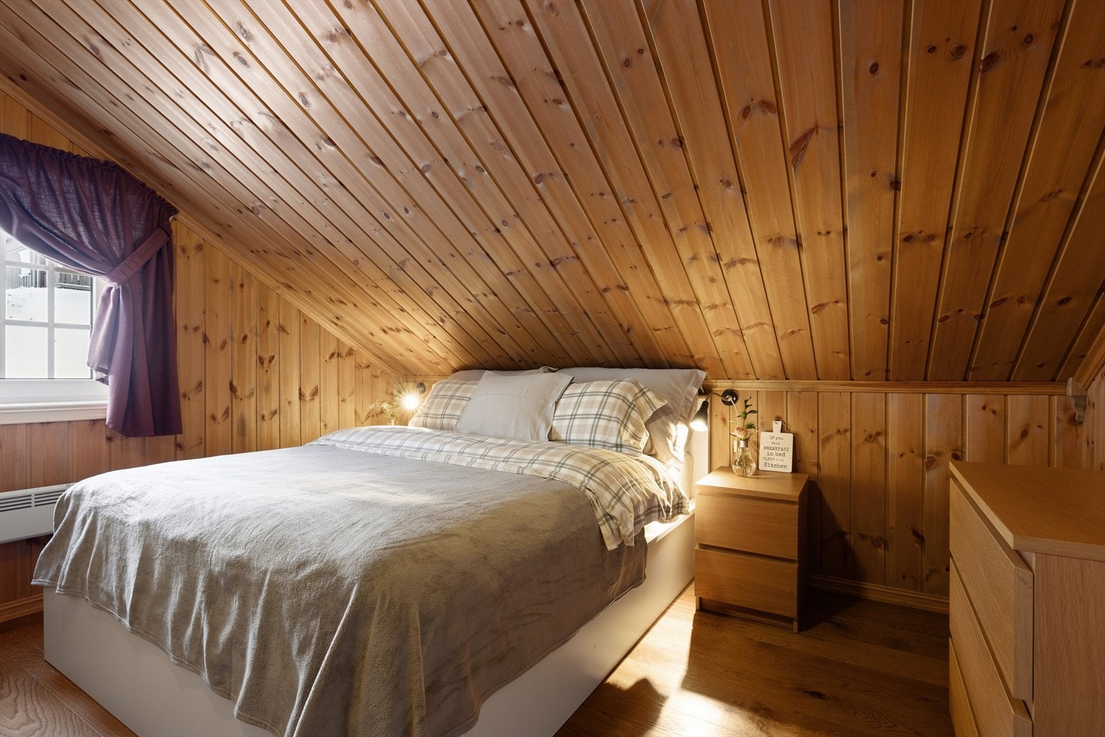 Soverom nummer to av hyttens tre rom - med skråtak og lune trepanel flater. Galleribilde