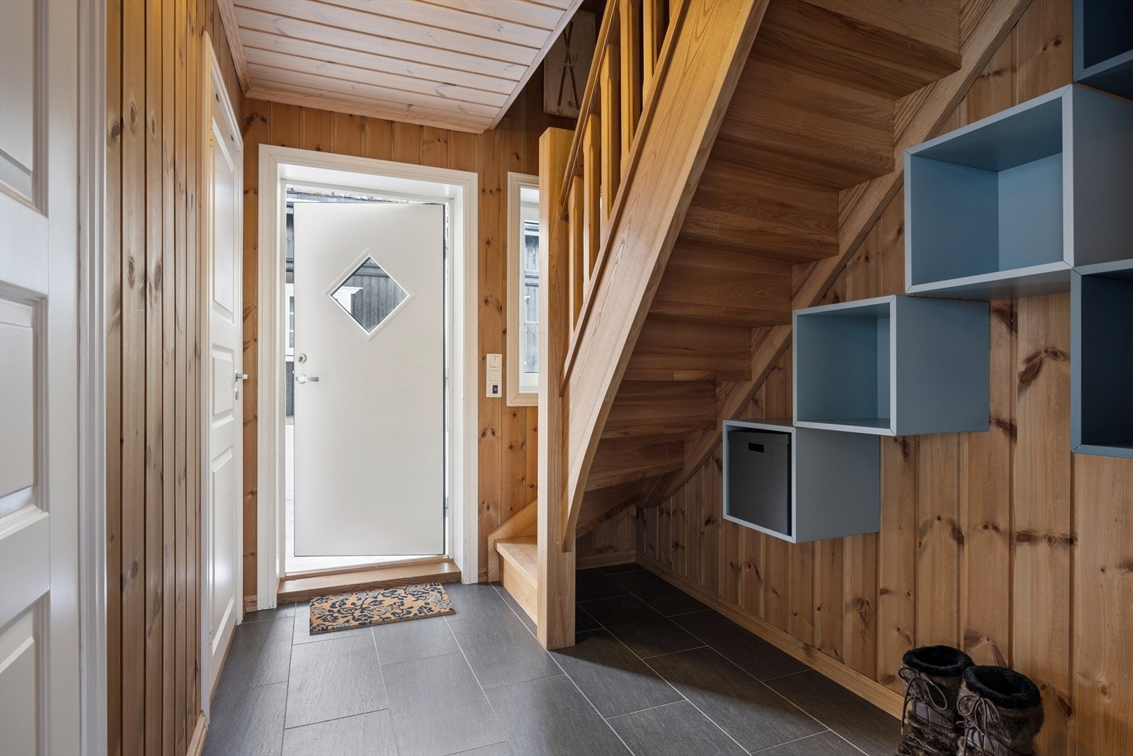 Praktisk og innbydende entré med god plass til yttertøy og sko. Flislagt gulv gjør det enkelt å holde rent, og trappen i tre gir en varm og klassisk hyttefølelse. Perfekt start på opplevelsen når du kommer inn fra fjellet! Galleribilde