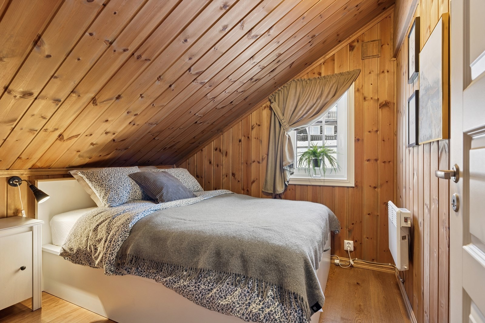 Ett av hyttens tre koselige soverom - med skråtak og trepanel som gir ekte hyttefølelse. Rommet har plass til dobbeltseng, perfekt for avslappende netter på fjellet. Galleribilde