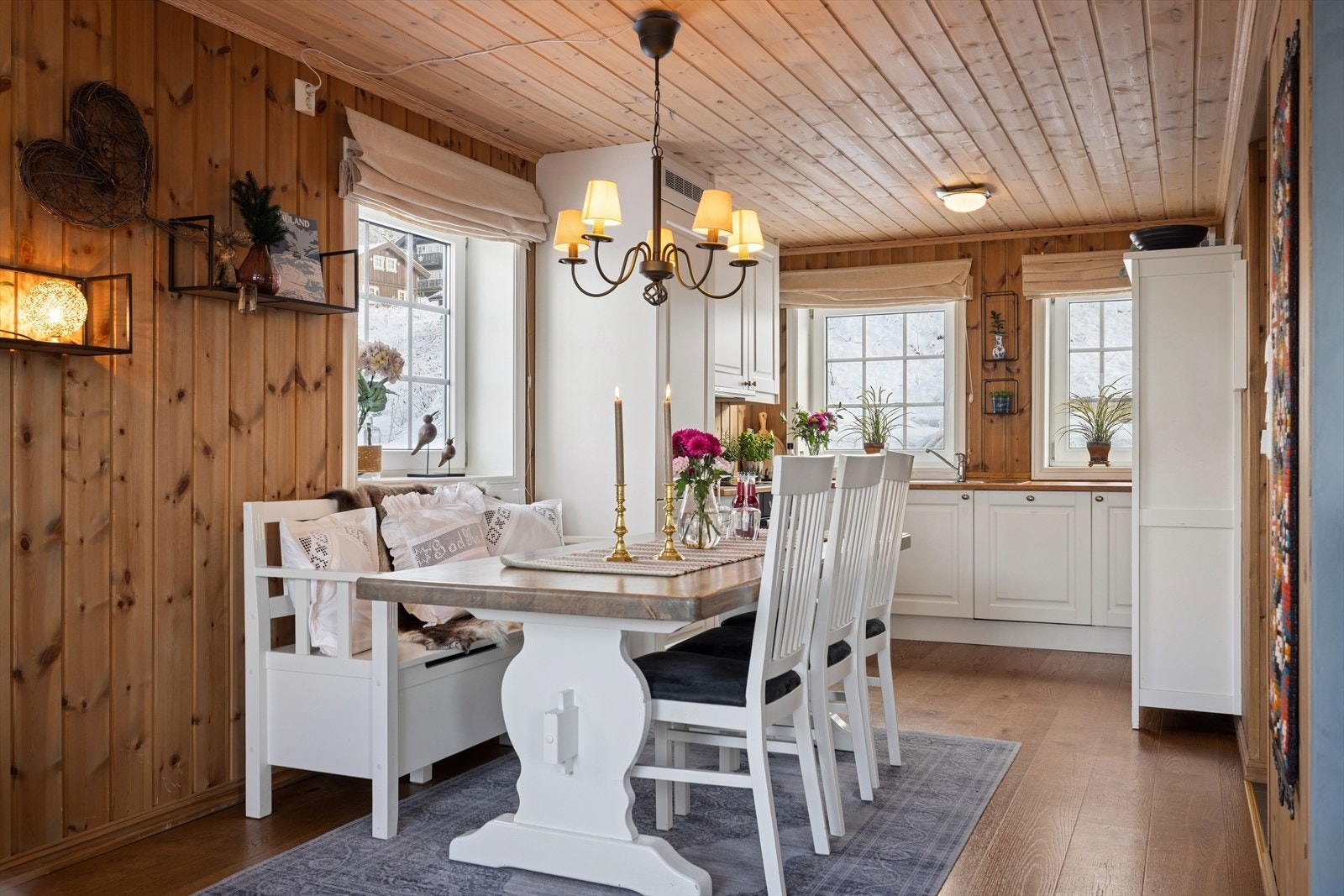 Lys og innbydende spiseplass med klassisk hyttepreg! Her kan du nyte måltider i en varm og koselig atmosfære. Den åpne løsningen mot kjøkkenet gjør rommet perfekt for både hyggelige familiemiddager og sosiale sammenkomster. Galleribilde