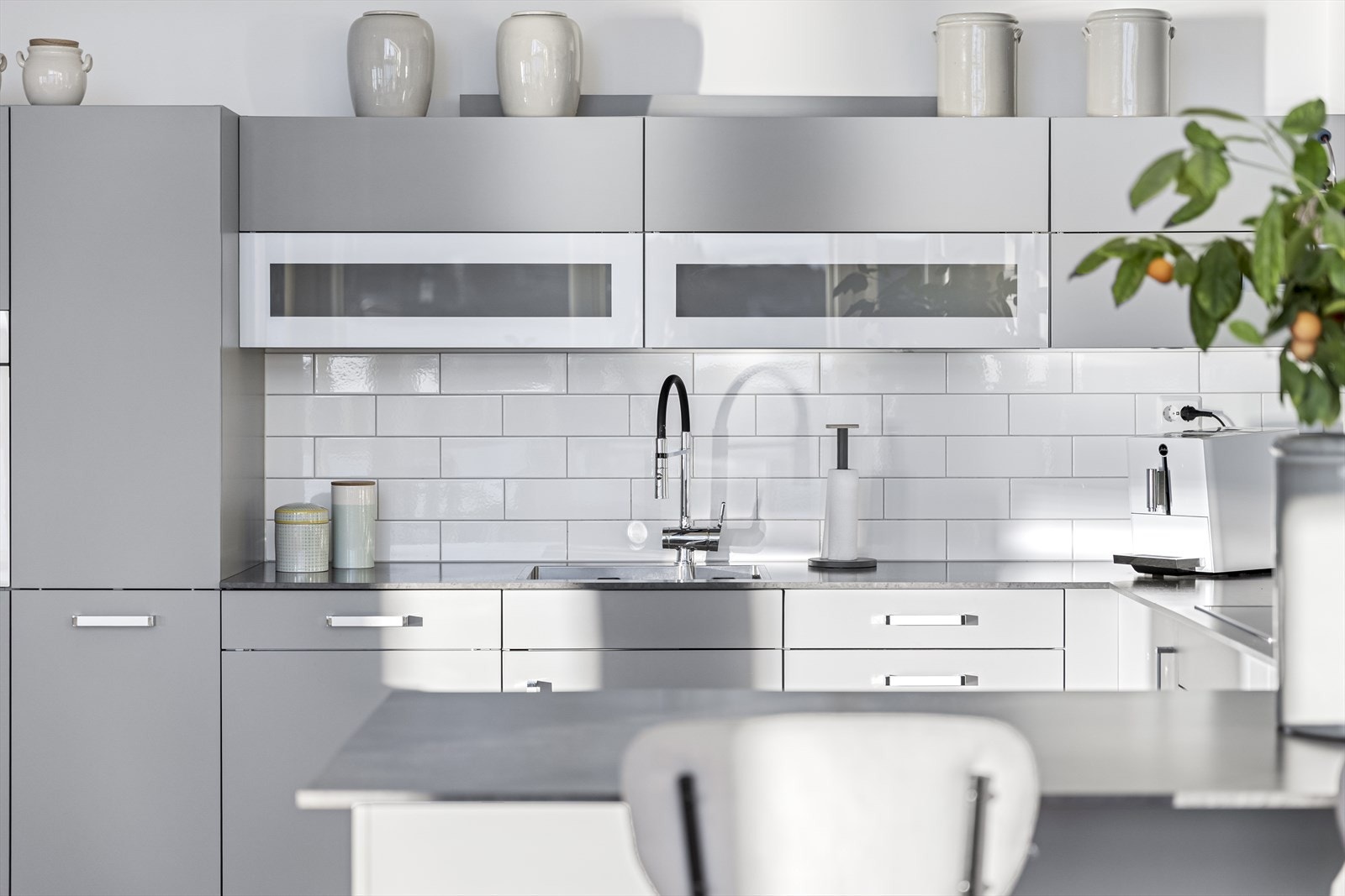 Det er fliser over kjøkkenbenk og praktisk halvøy mot spisestuen som fungerer som frokostbar. Galleribilde