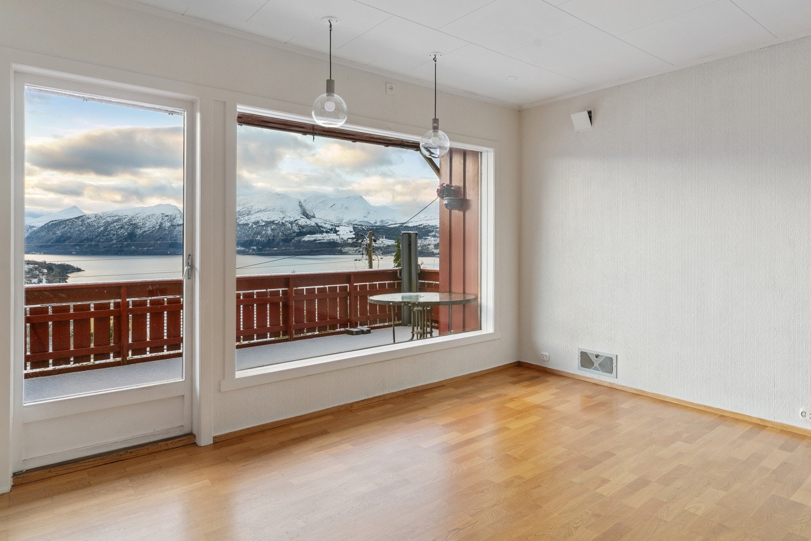 Store vindaugsflater slepp inn rikeleg med dagslys og tek landskapet inn i stova Galleribilde