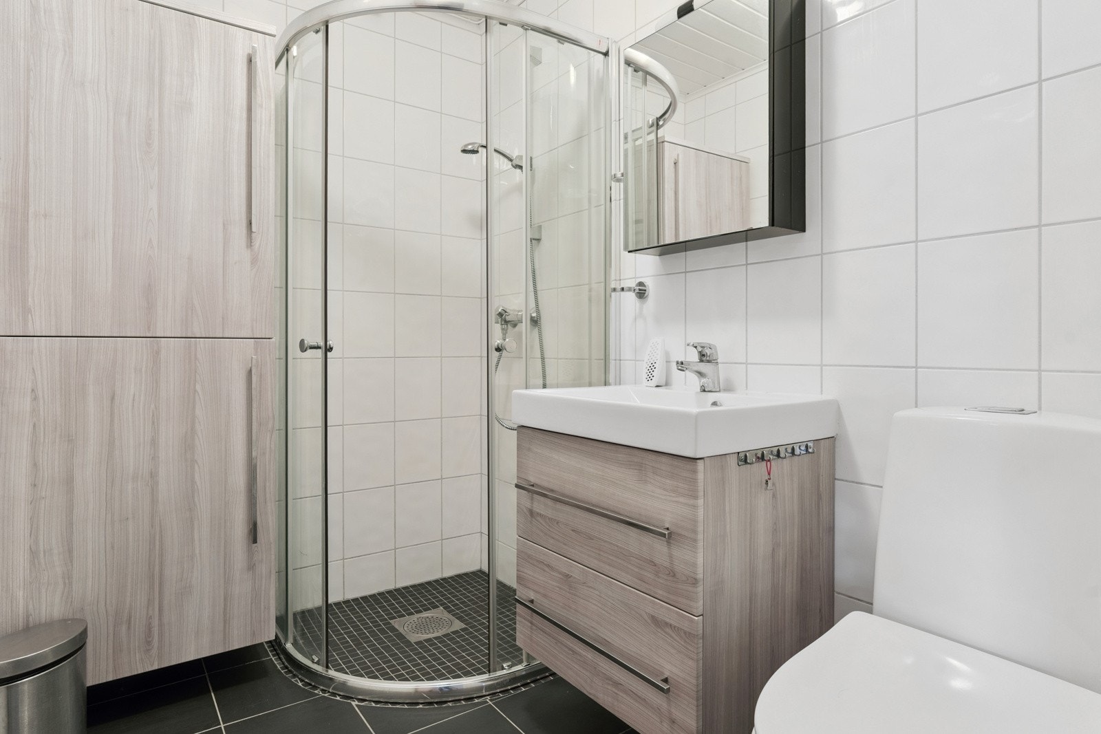 Moderne flislagt bad med pen innreiing. God oppbevaringsplass i veggskap og skuffer gjer det enkelt å halde orden og system på badet. Galleribilde