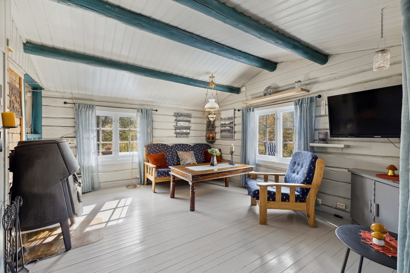 Stuen er lys og koselig. Høy himling og åpne tømmeåser gir en god romfølelse Galleribilde