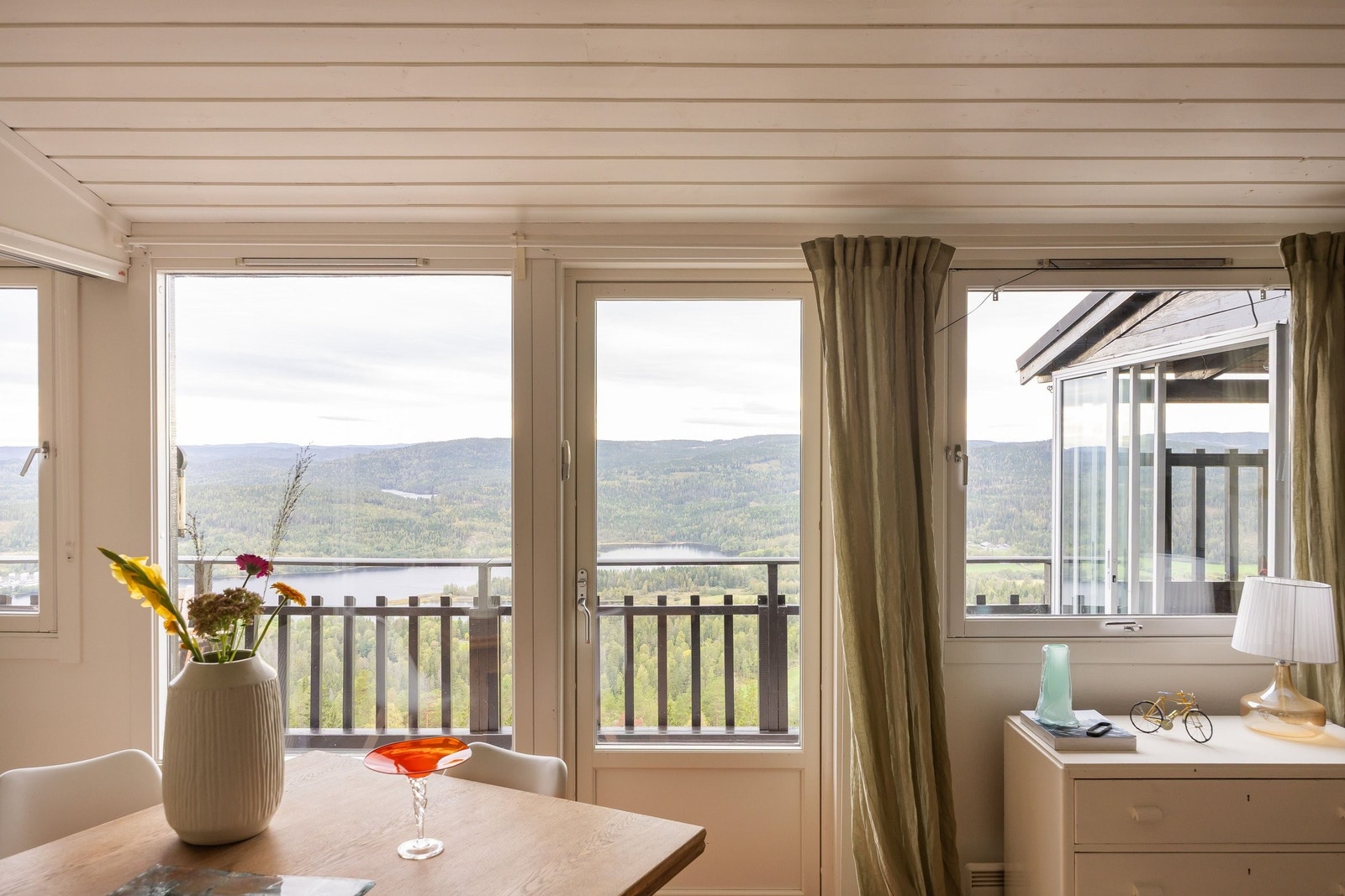 solrik, lys og luftig stue med stor takhøye og hems.
Bildet er tatt fra kjøkkenet mot vest.
Den fantastiske utsikten preger hele leiligheten. Galleribilde