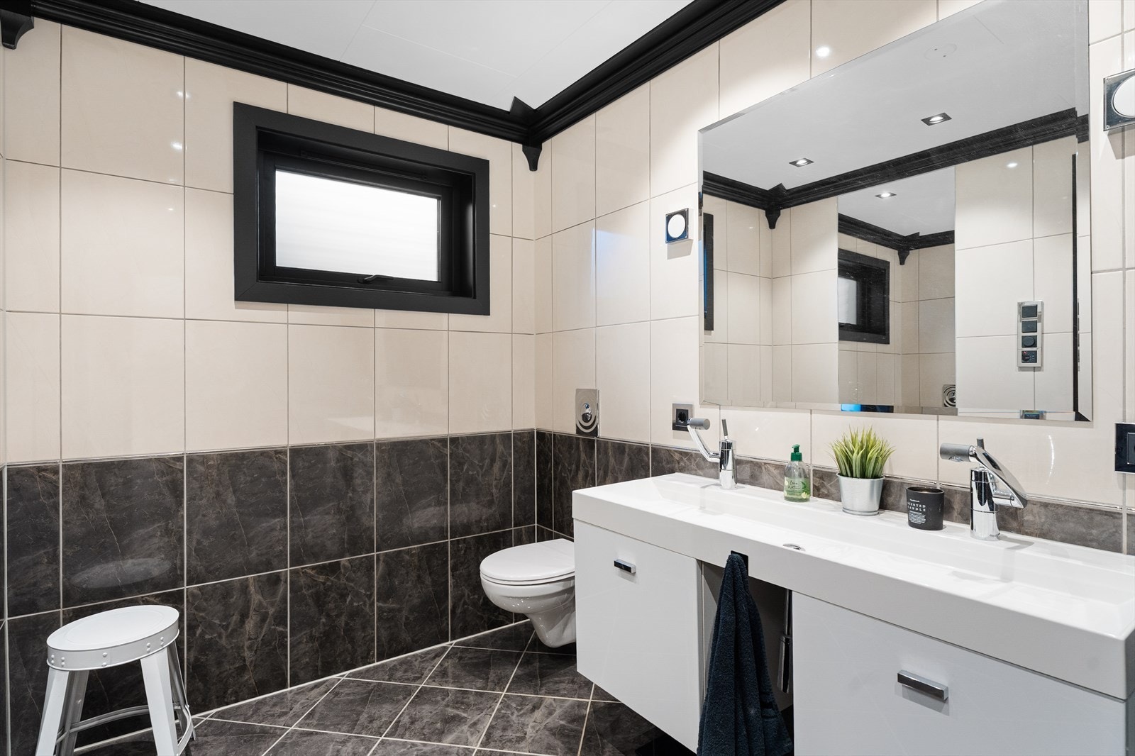 Badet har heldekkende servant, dusjhjørne og vegghengt toalett, samt elektrisk styrt vifte Galleribilde