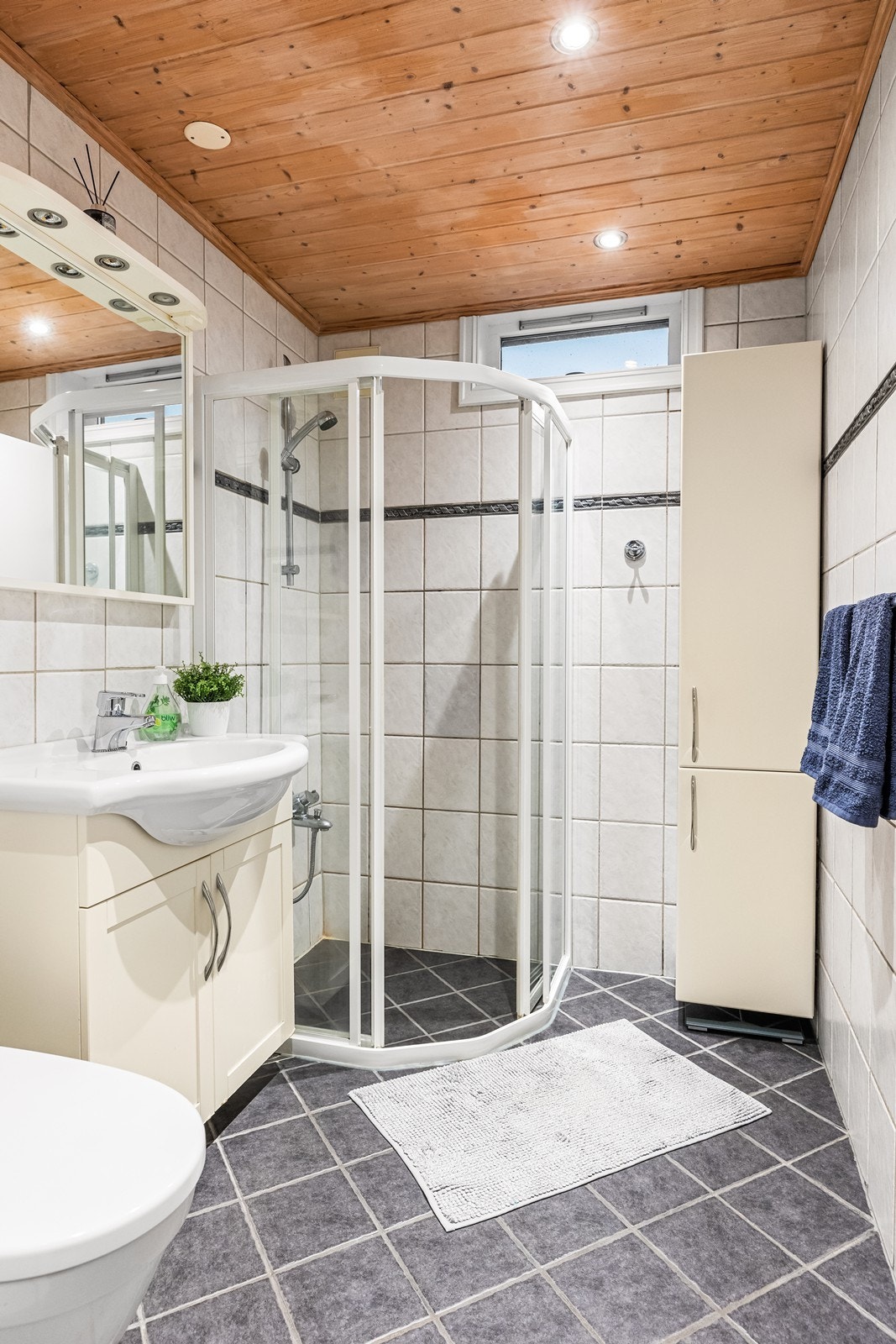 Helfliset baderom med underliggende varmekabler og innfelte downlights i himlingen Galleribilde