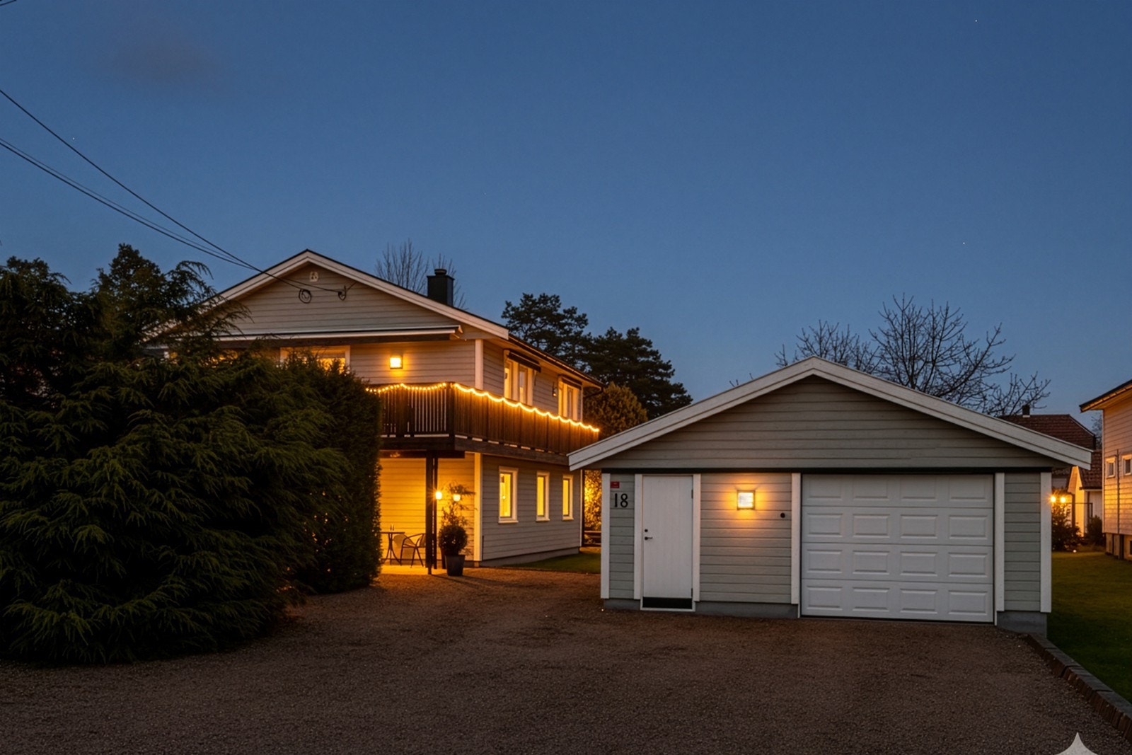 Gruset gårdsplass med gangbaner og kantstein mot gressplen, og romslig enkel garasje Galleribilde