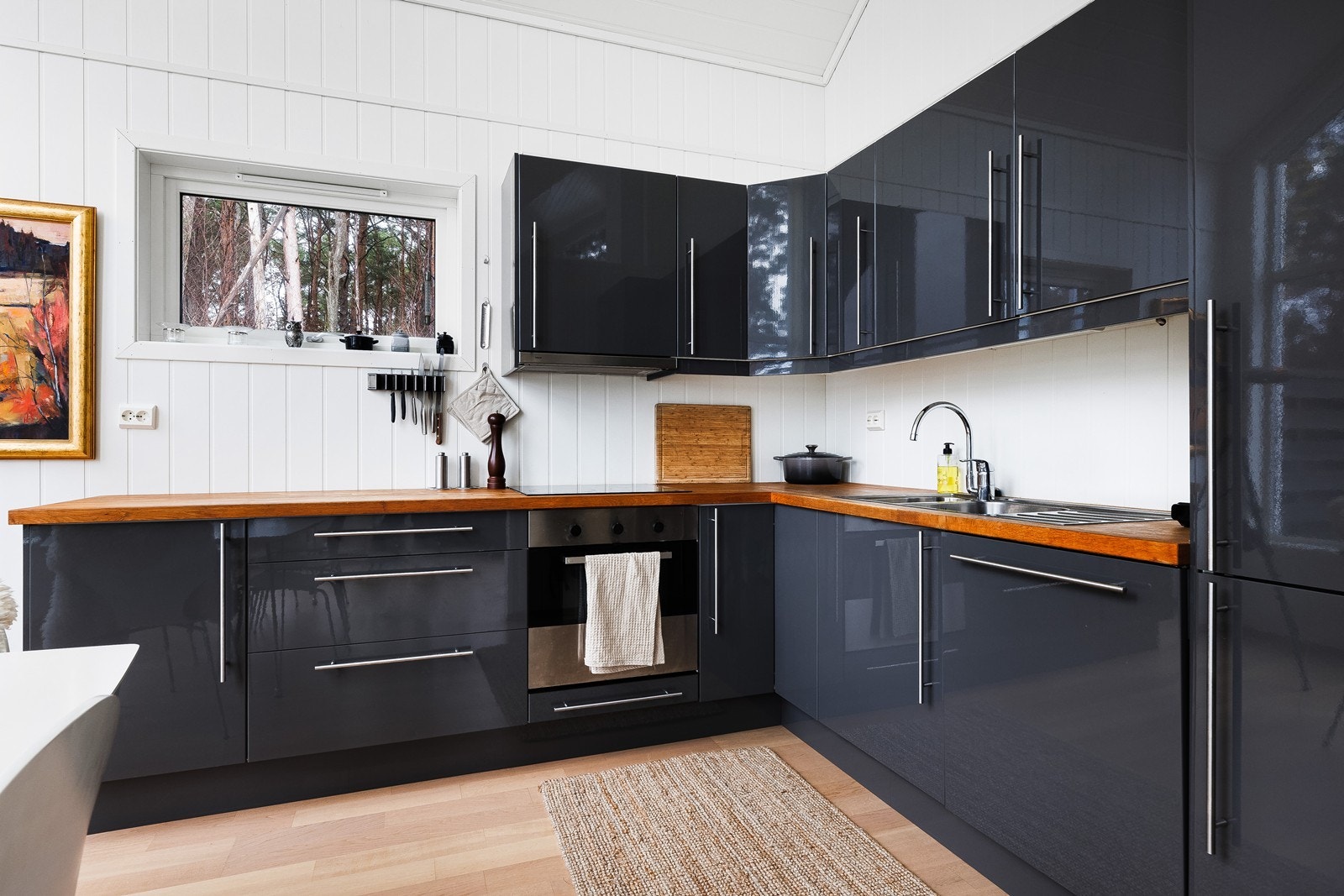 Kjøkkenet er godt utstyrt med slette fronter og integrerte hvitevarer Galleribilde