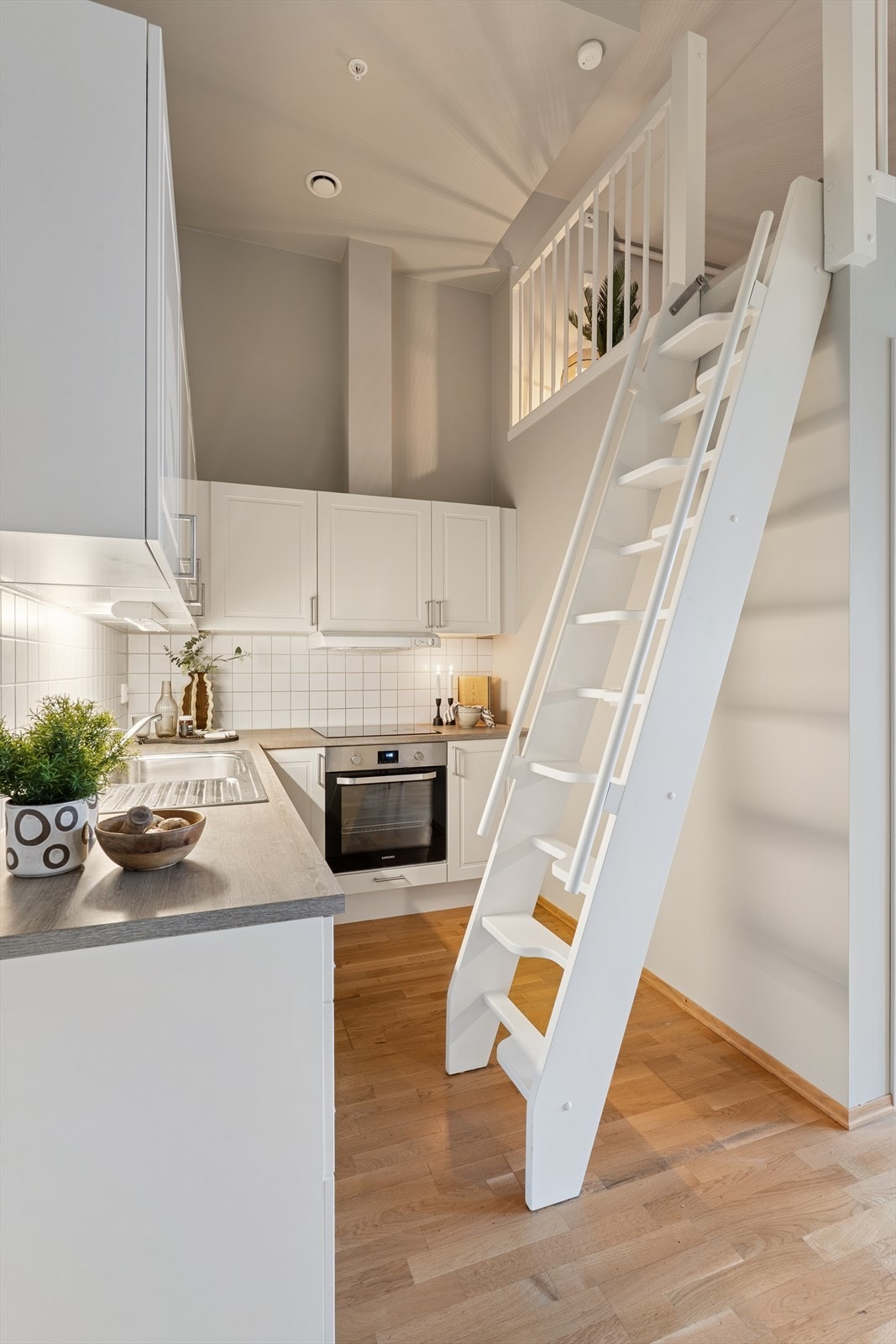 Fra kjøkkenet ledes du via trapp opp til hemsen - en smart og plassbesparende løsning som gir boligen ekstra funksjonalitet. Galleribilde