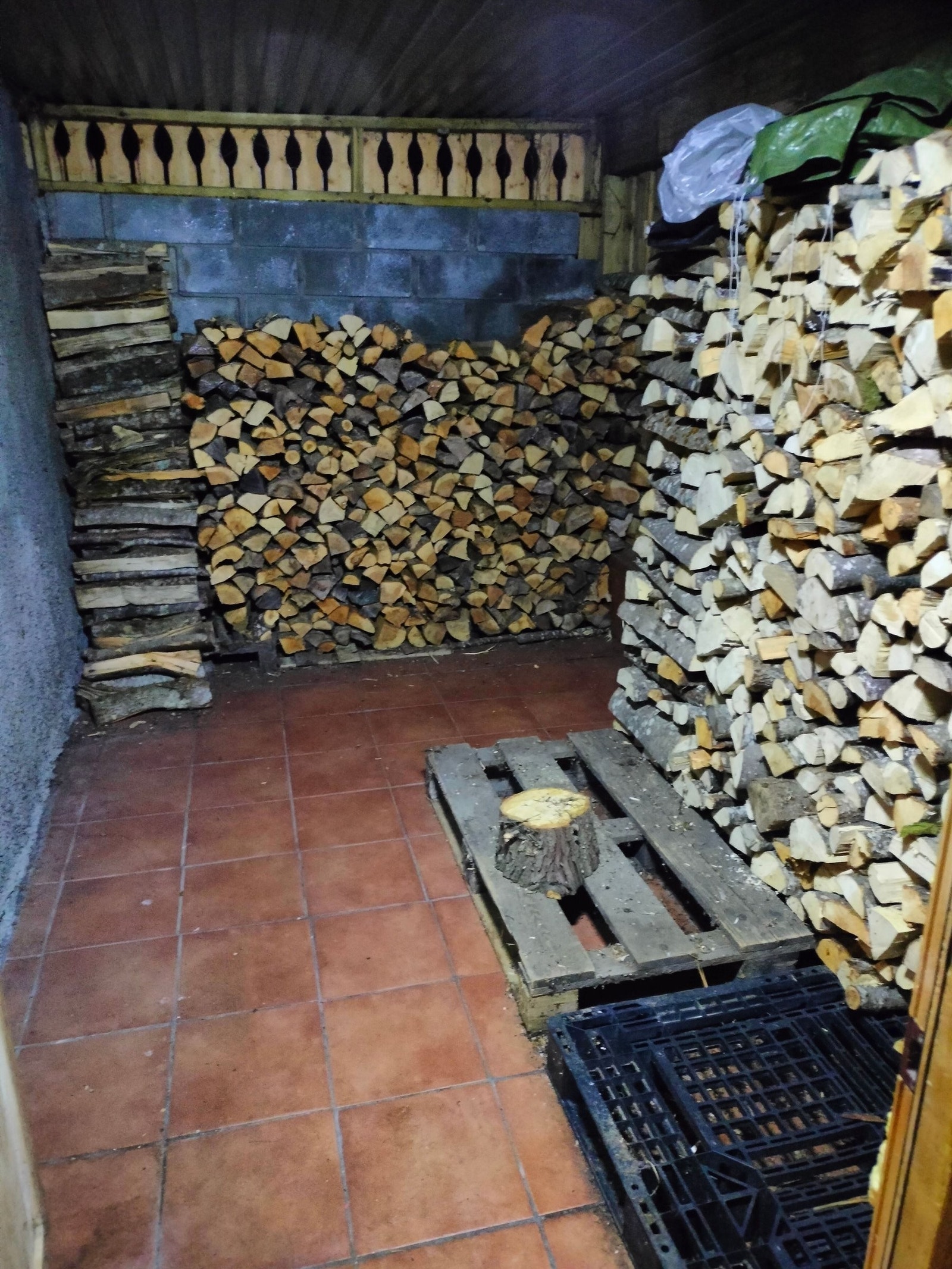 Vedbod under terrassen med dør ut til hage og inn til stue i underetasjen. Galleribilde