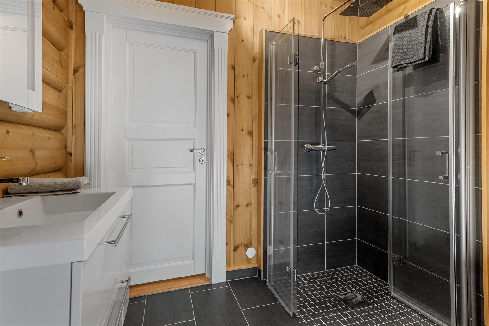 Loftsetasjen har eget baderom som inneholder servant med skap, toalett og dusjhjørne. Gulvet er flislagt. Galleribilde