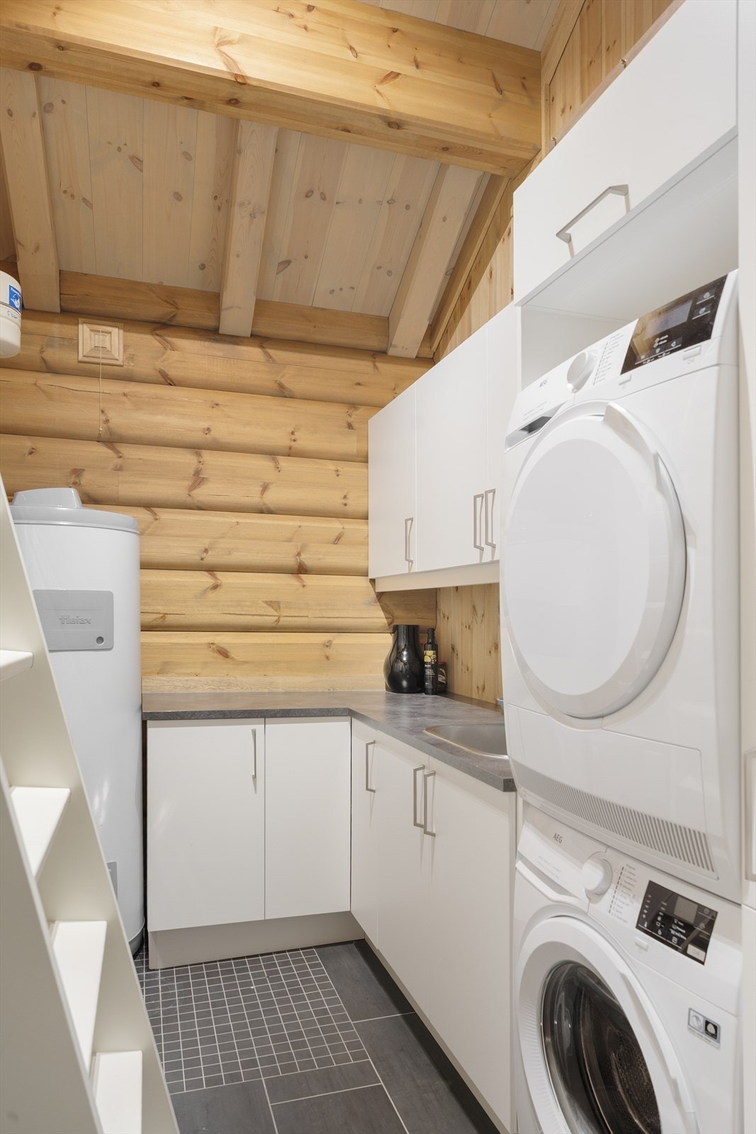 Separat vaskerom/bod/teknisk rom innredet med praktisk vaskeromsinnredning, opplegg for vaskemaskin, rør-i-rør skap, varmtvannsbereder og utslagsvask. Gulvvarme. Stige til praktisk oppbevaringsplass for ski o.l. Galleribilde