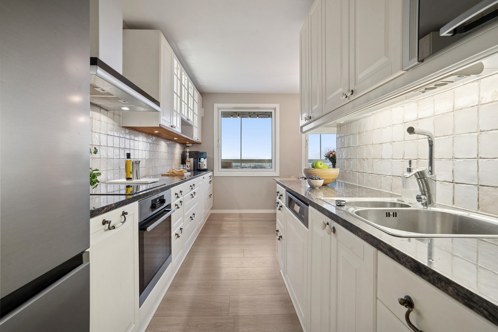 Lyst og tidløst kjøkken som byr på godt med skuff- og skapplass samt fine arbeidsflater Galleribilde