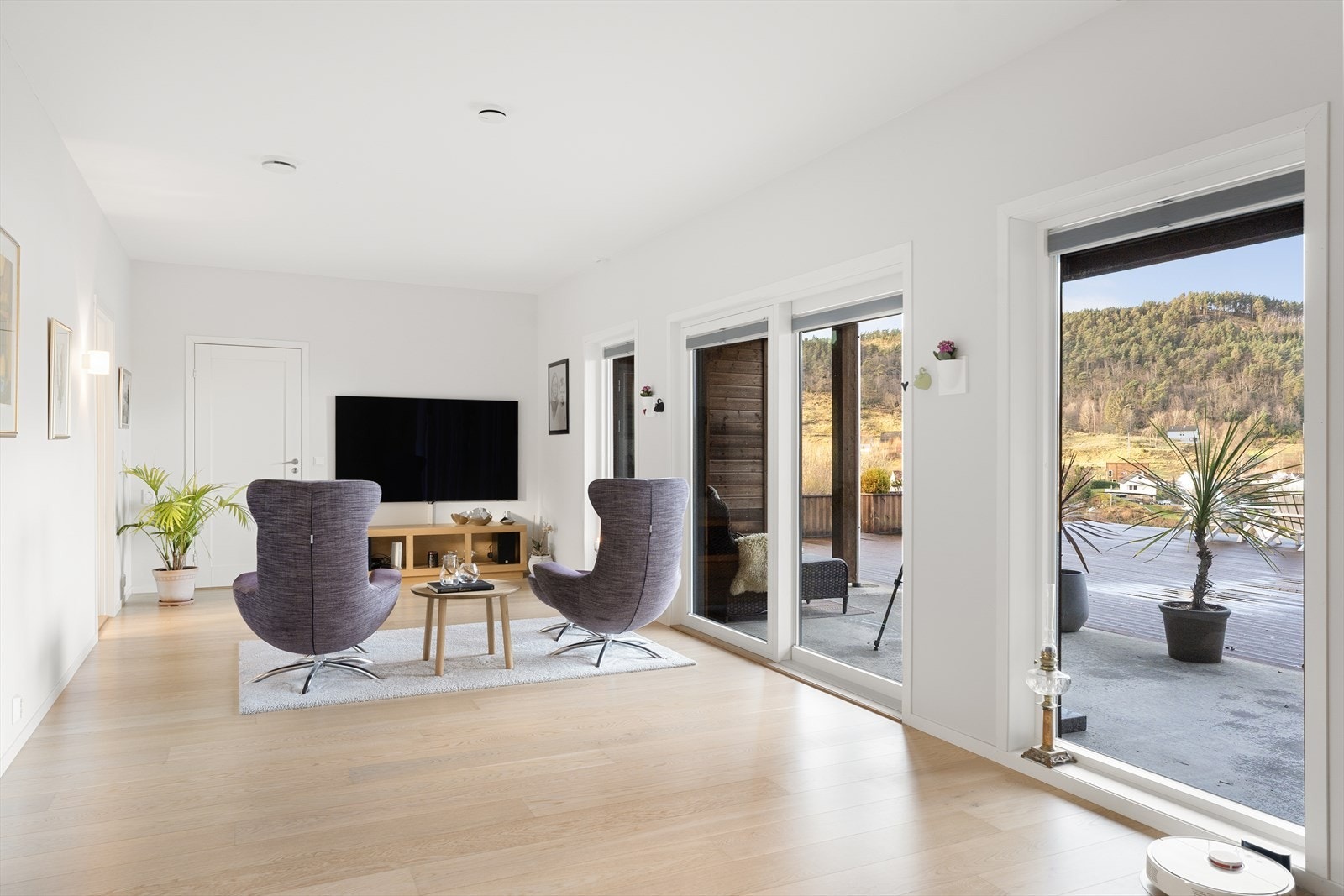 Lys og flott tv-stue med direkte utgang til det store terrasseområdet Galleribilde