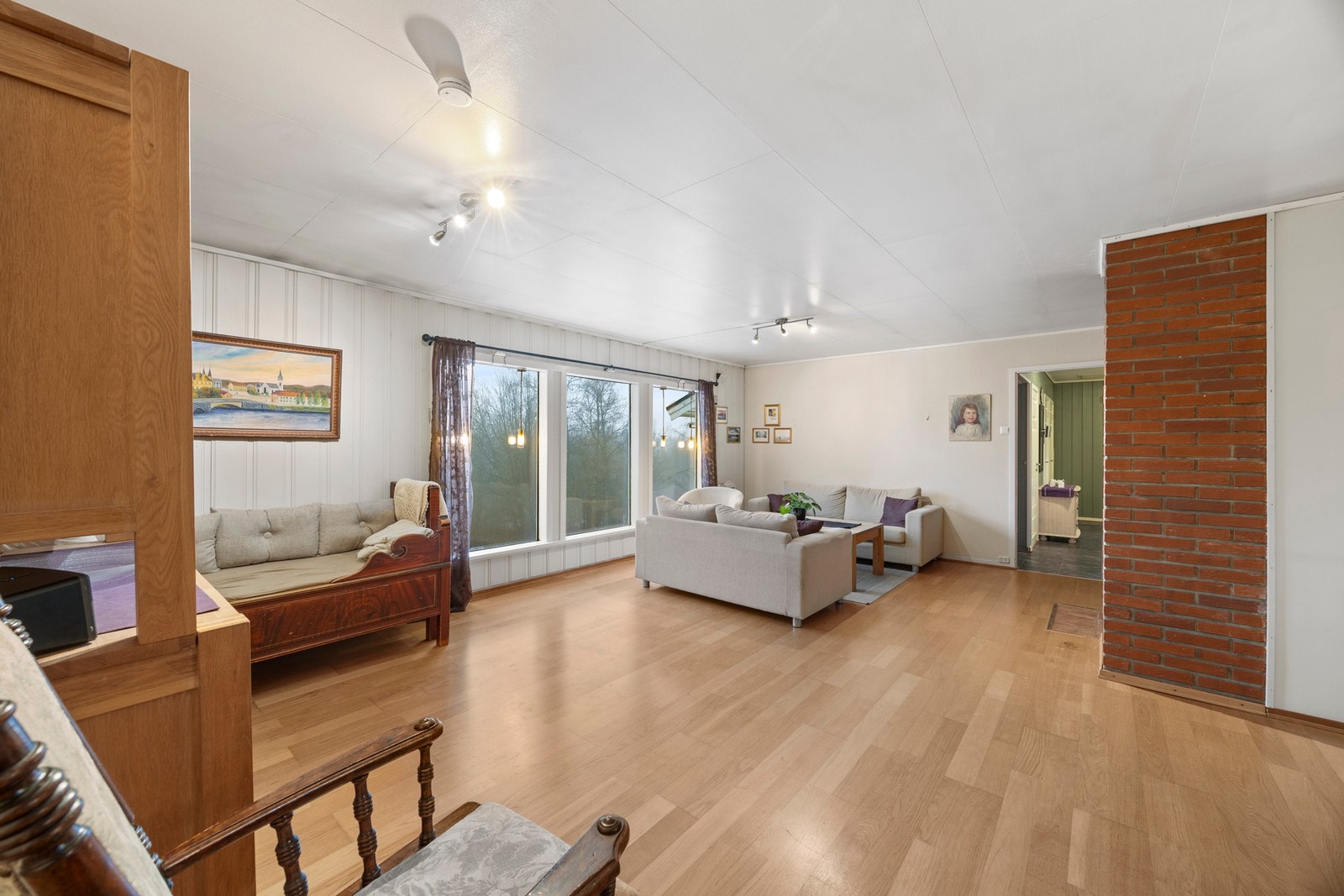 Store vindusflater slipper dagslyset inn og skaper en lys og innbydende atmosfære. Galleribilde