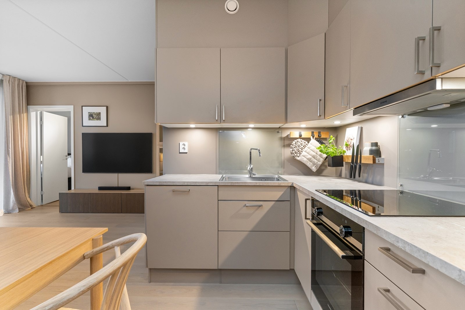 Lekkert kjøkken med god skapplass og integrerte hvitevarer Galleribilde