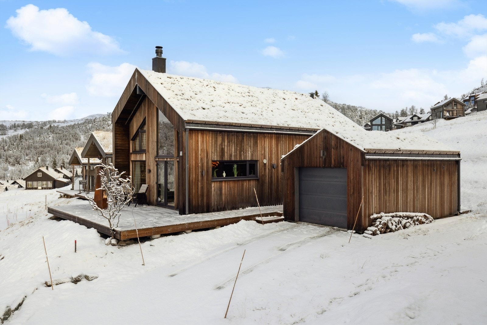 Parkering i garasje med tilhørende bod og badstue. Hytten ligger med gode uteområder, perfekt for familie og gjester. Galleribilde