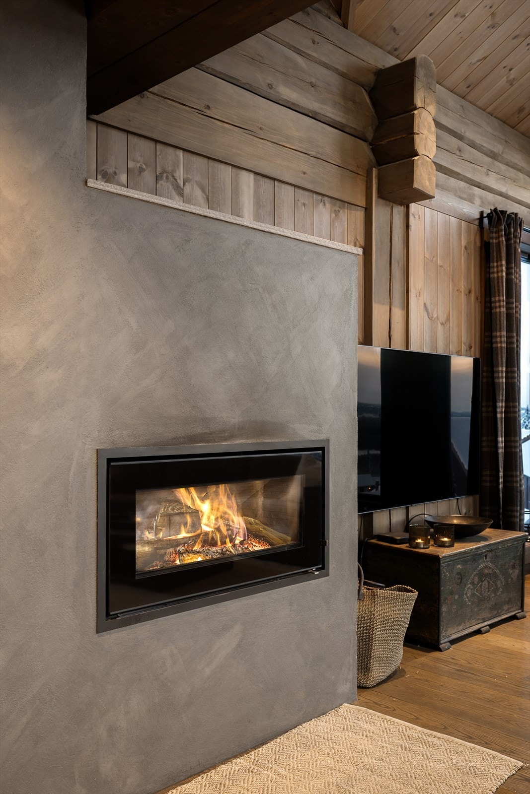 Peisen er elegant integrert i en pusset overflate som står i kontrast til treverket. Galleribilde