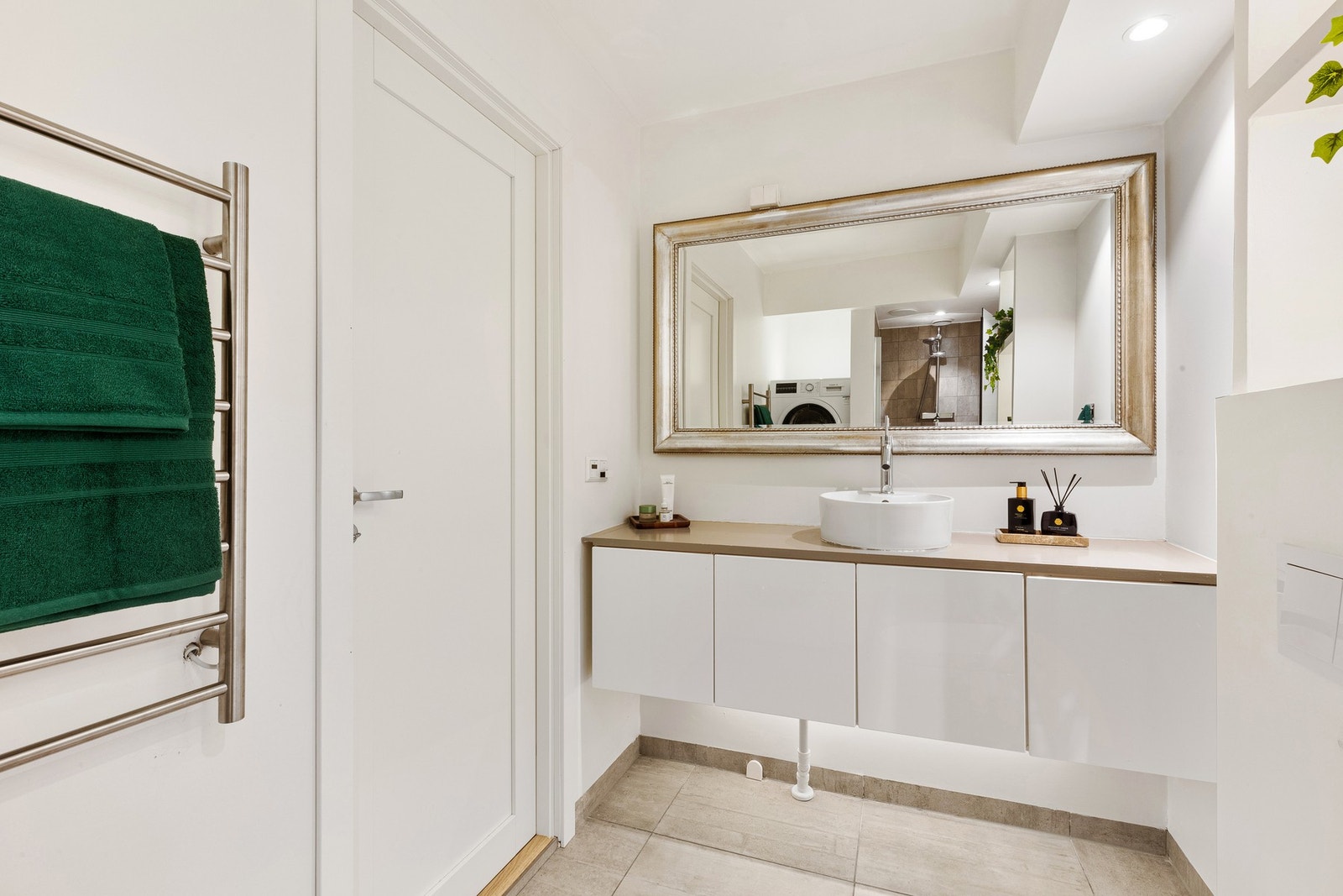 Innredningen består blant annet av vegghengt servantmøbel med glatte fronter, benkeplate i laminat og ovenpåliggende servant med ett-greps armatur. Galleribilde