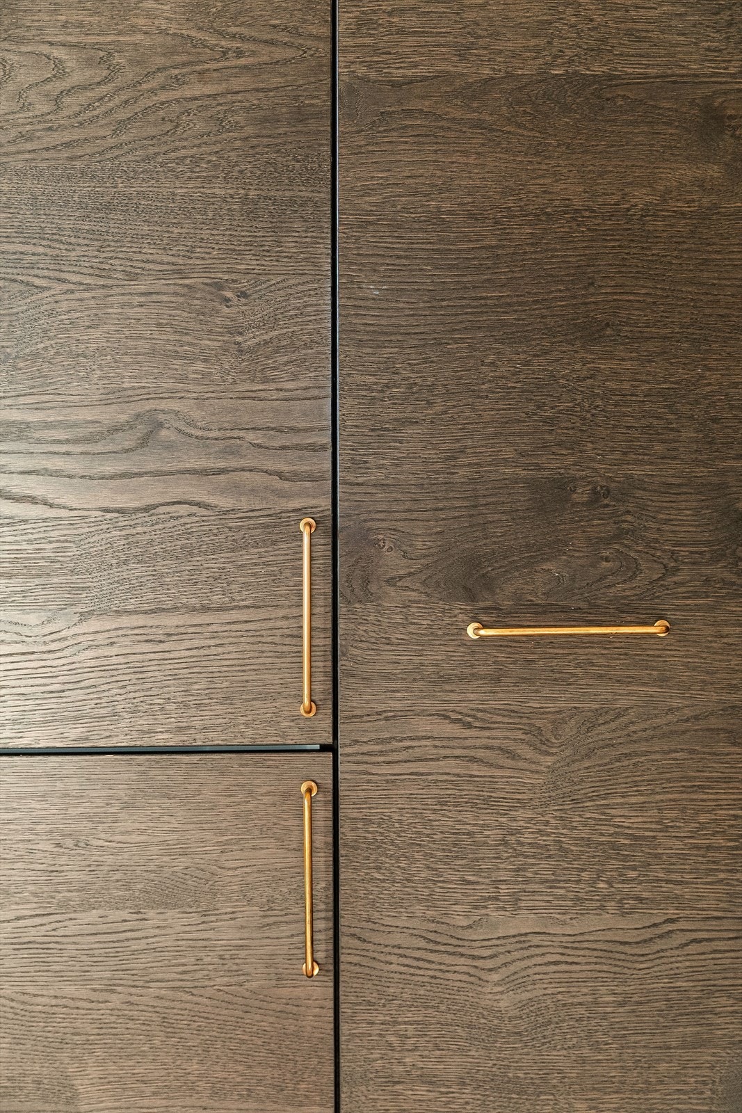 Pene detaljer på kjøkken med gullhåndtak og beiset tre. Galleribilde