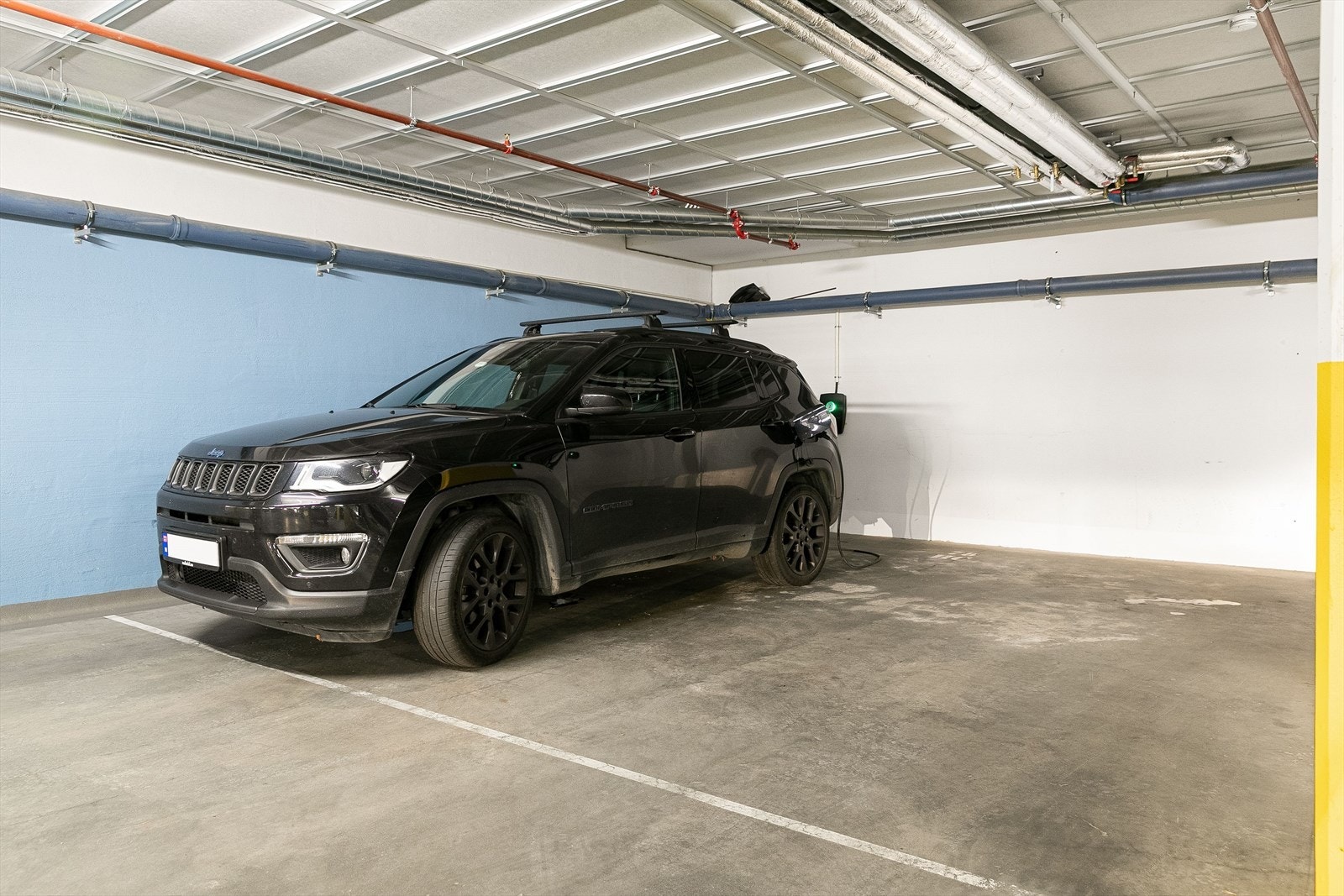 I tillegg disponerer leiligheten en stor garasjeplass (hele denne plassen) med elbillader. Det er heis fra garasjekjeller til leilighetsplan. Galleribilde