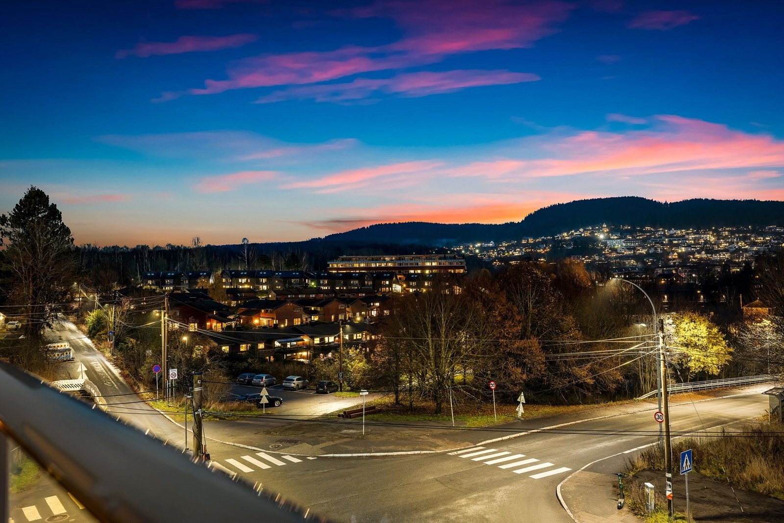 Balkongen er overbygget, har terrassebord på gulv og rekkverk av metallkonstruksjon med felter i herdet glass. Galleribilde